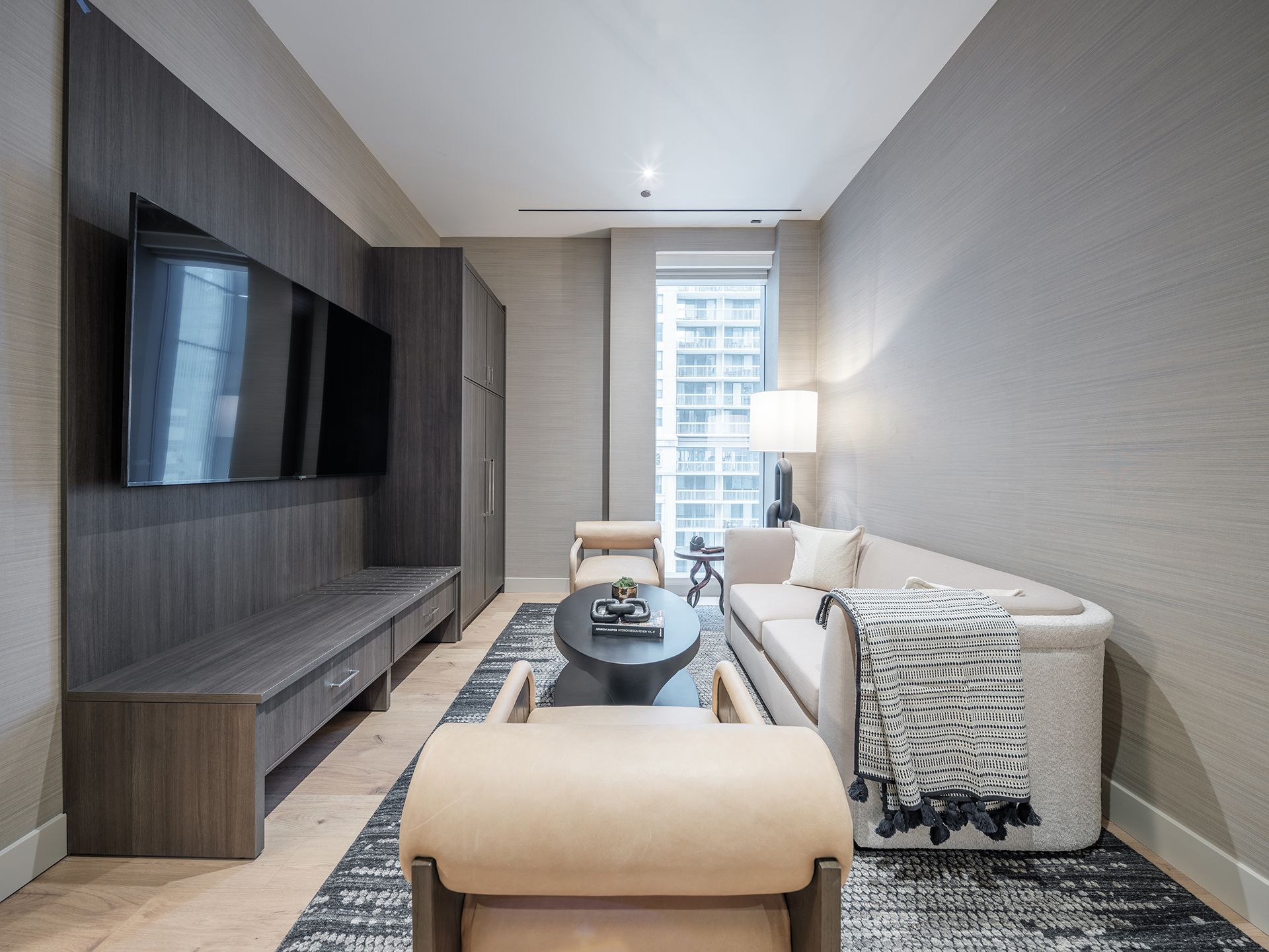A living room with a couch , chair , coffee table and television.