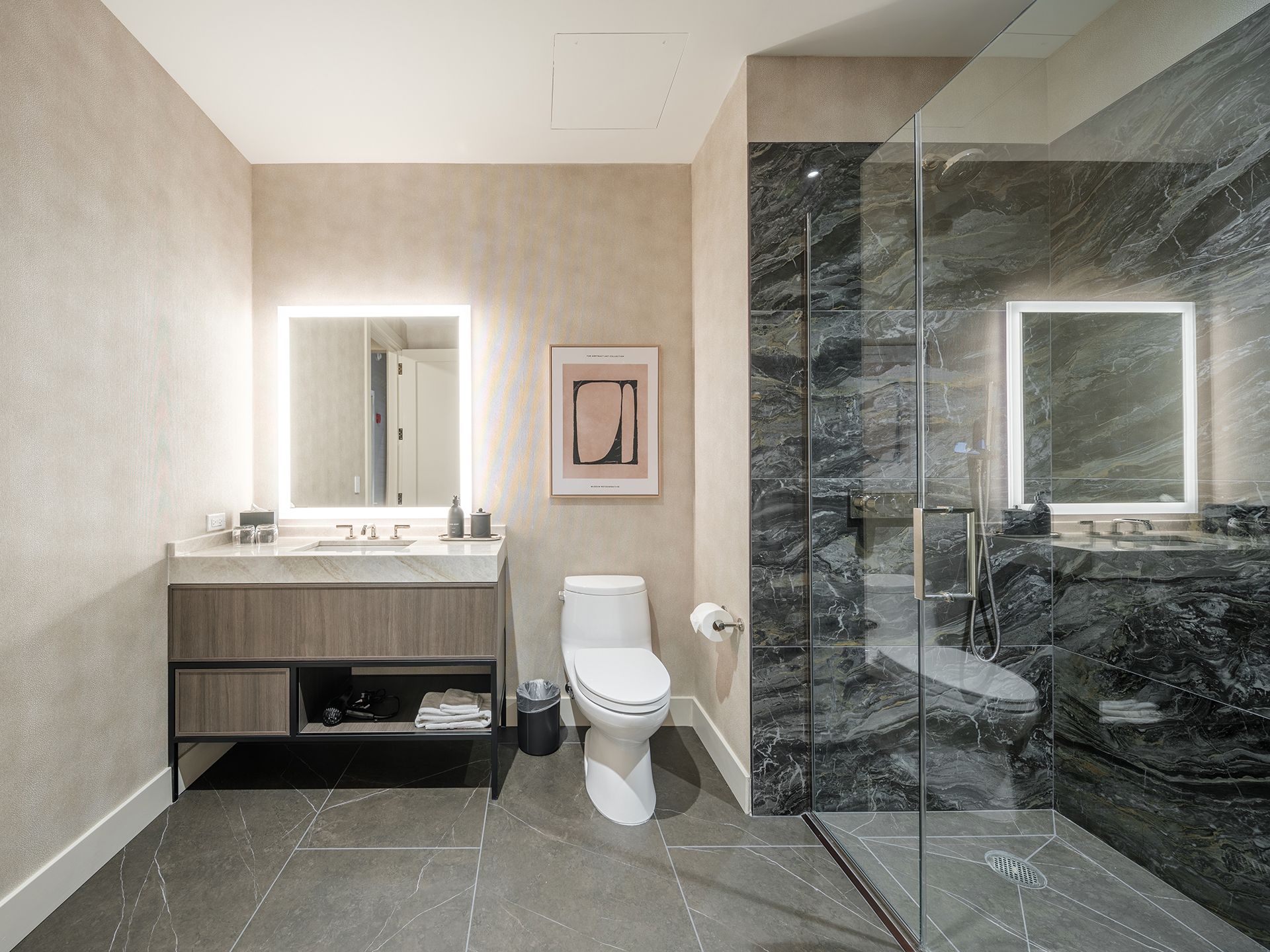 A bathroom with a toilet , sink , mirror and walk in shower.