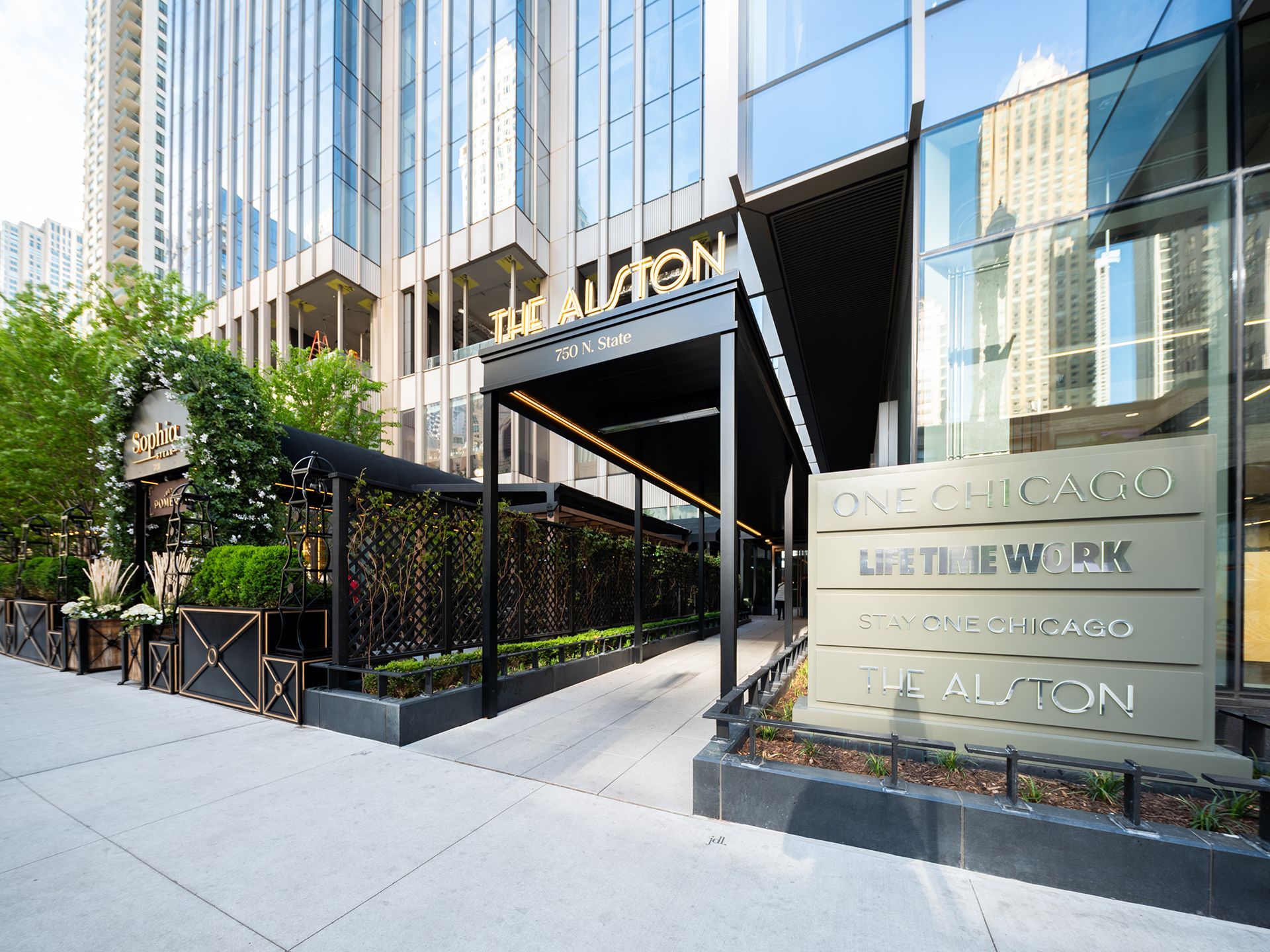 A large building with a sign on the sidewalk in front of it.