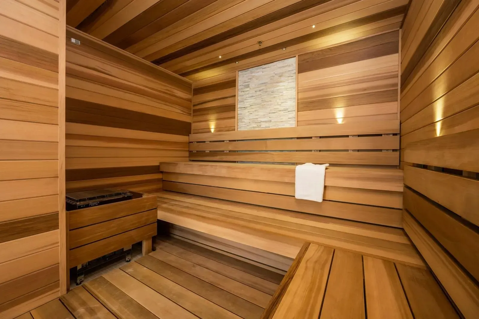 A wooden sauna with a towel hanging on the wall.