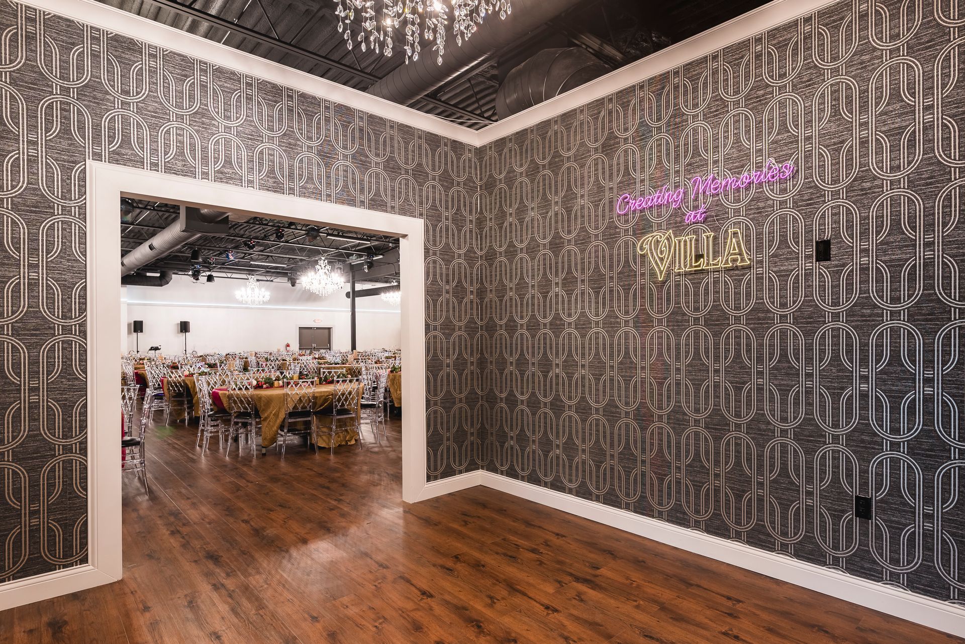 A restaurant table set with plates, glasses, and silverware; ready for guests. The setting is outdoors, with neutral tones.