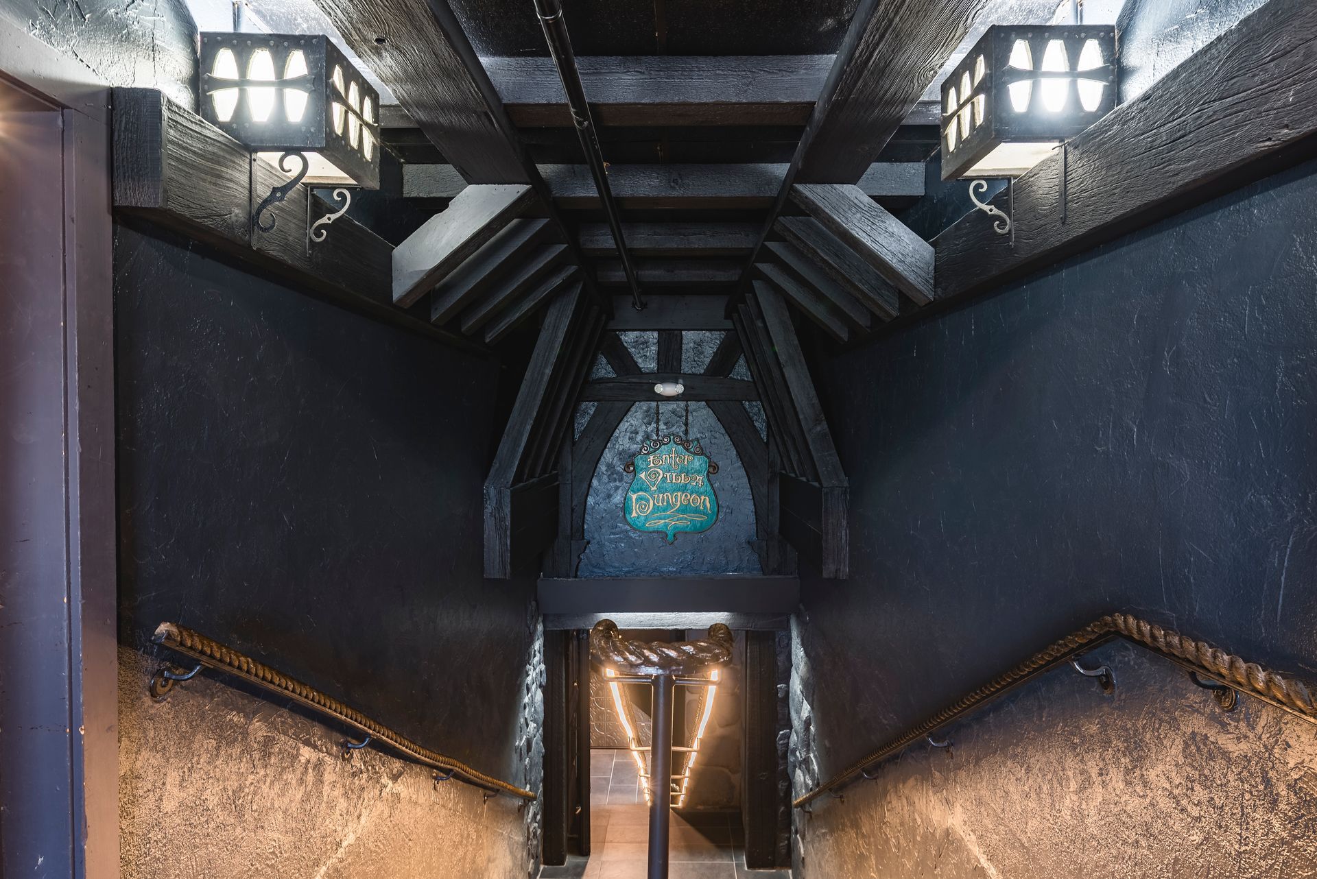 Elegant dinner table set with glassware, candles, and green drinking glasses. Table is white, set in a dimly lit room.