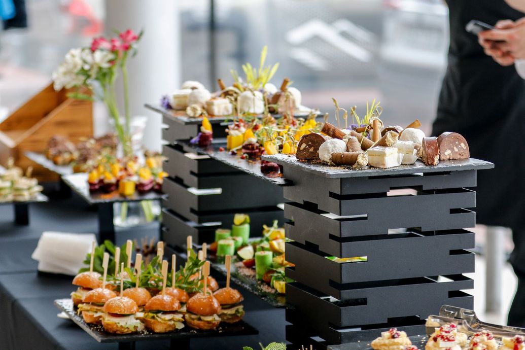 A buffet table laden with appetizers, featuring stacked black serving displays.