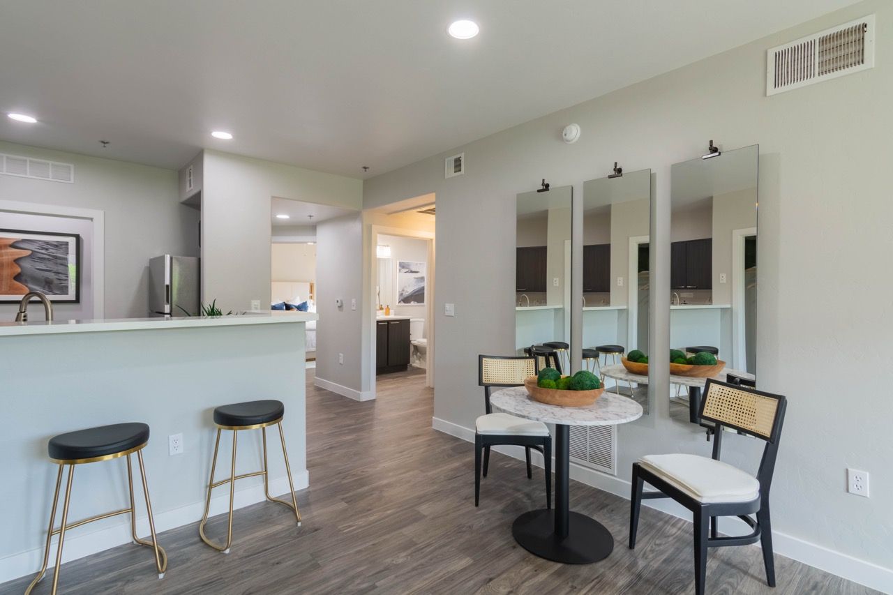 Bright kitchen with counter, stools, and a round marble table at Legacy Apartments at Dove Mountain in Marana, AZ.