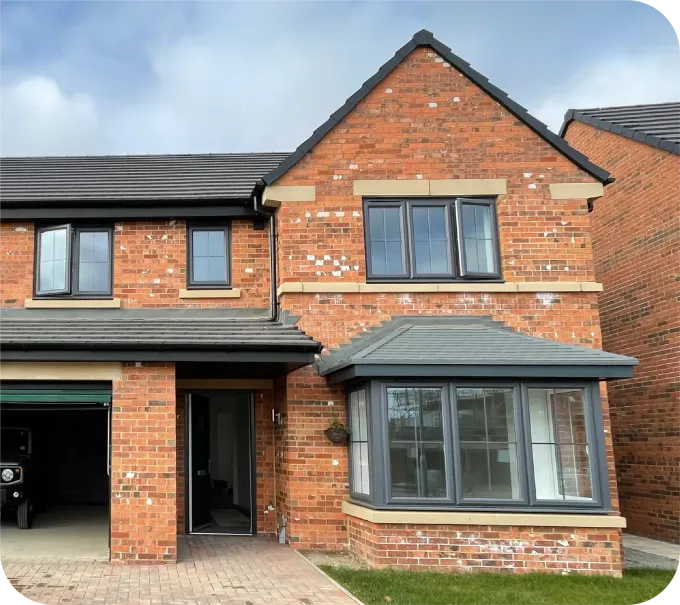 A two-story brick suburban house with a dark-framed bay window, a small front entrance, and an attached garage.