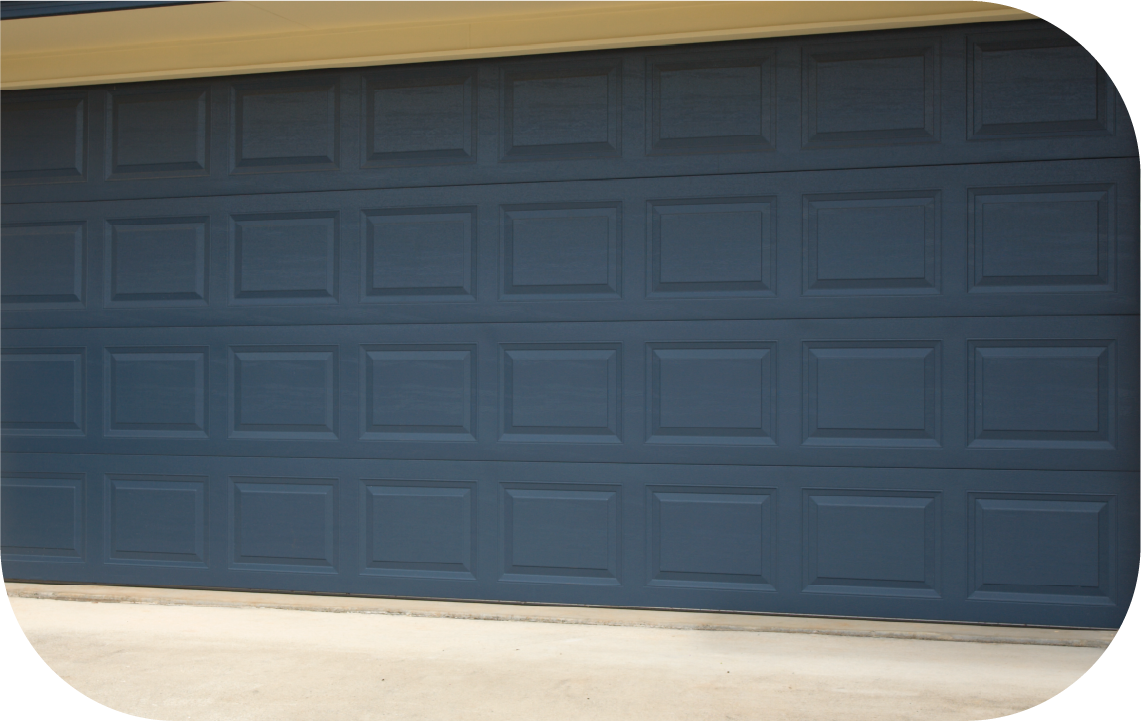 A dark blue garage door with a grid of rectangular raised panels installed on a home.