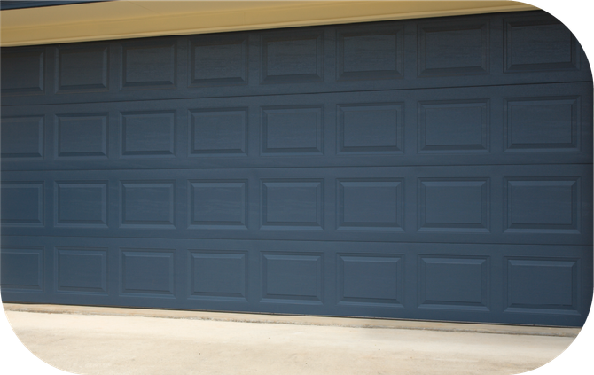 A dark blue garage door with a grid of rectangular raised panels installed on a home.