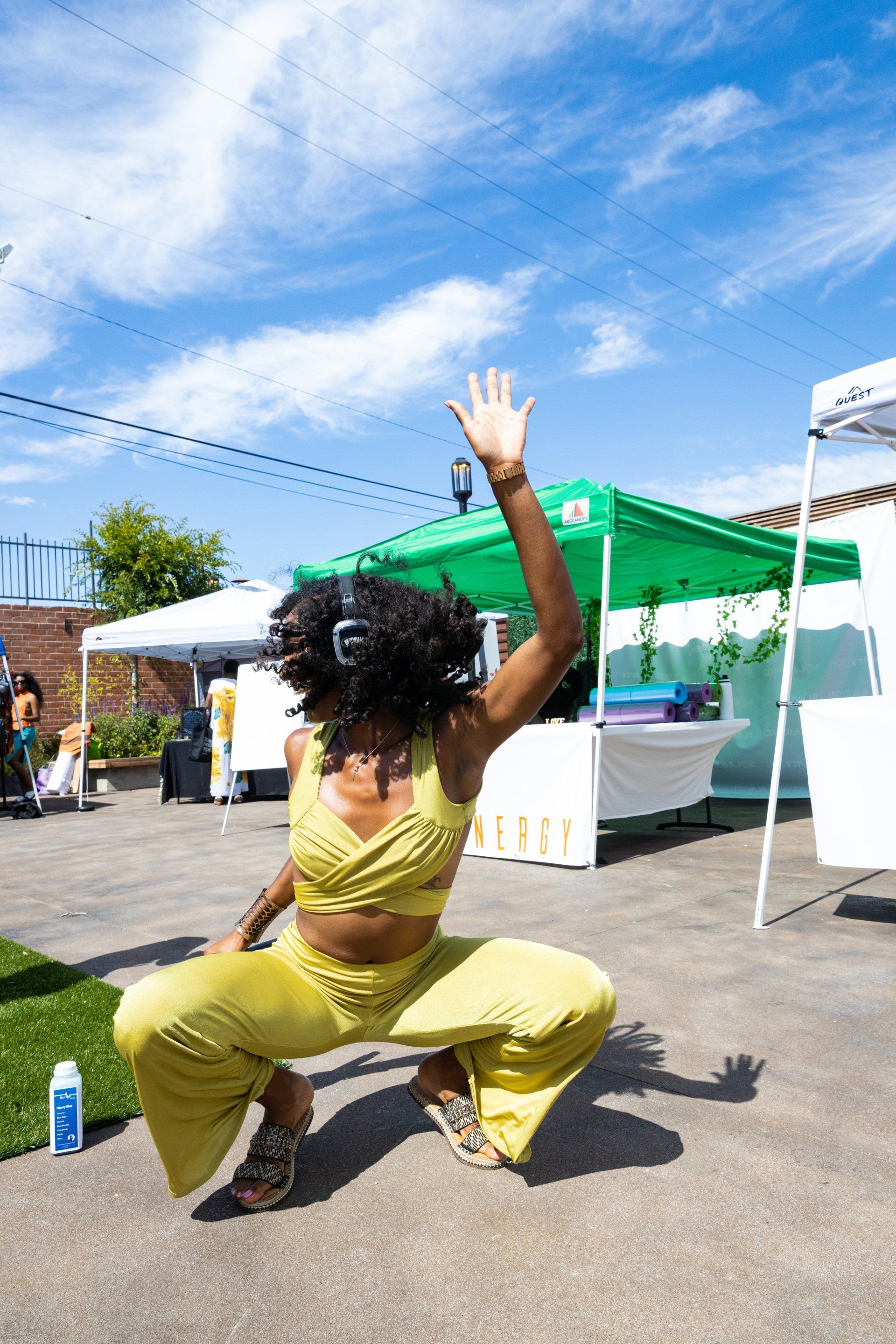 Janelle is wearing headphones and dancing during outdoor ecstatic dance at Sol & Sound Festival.