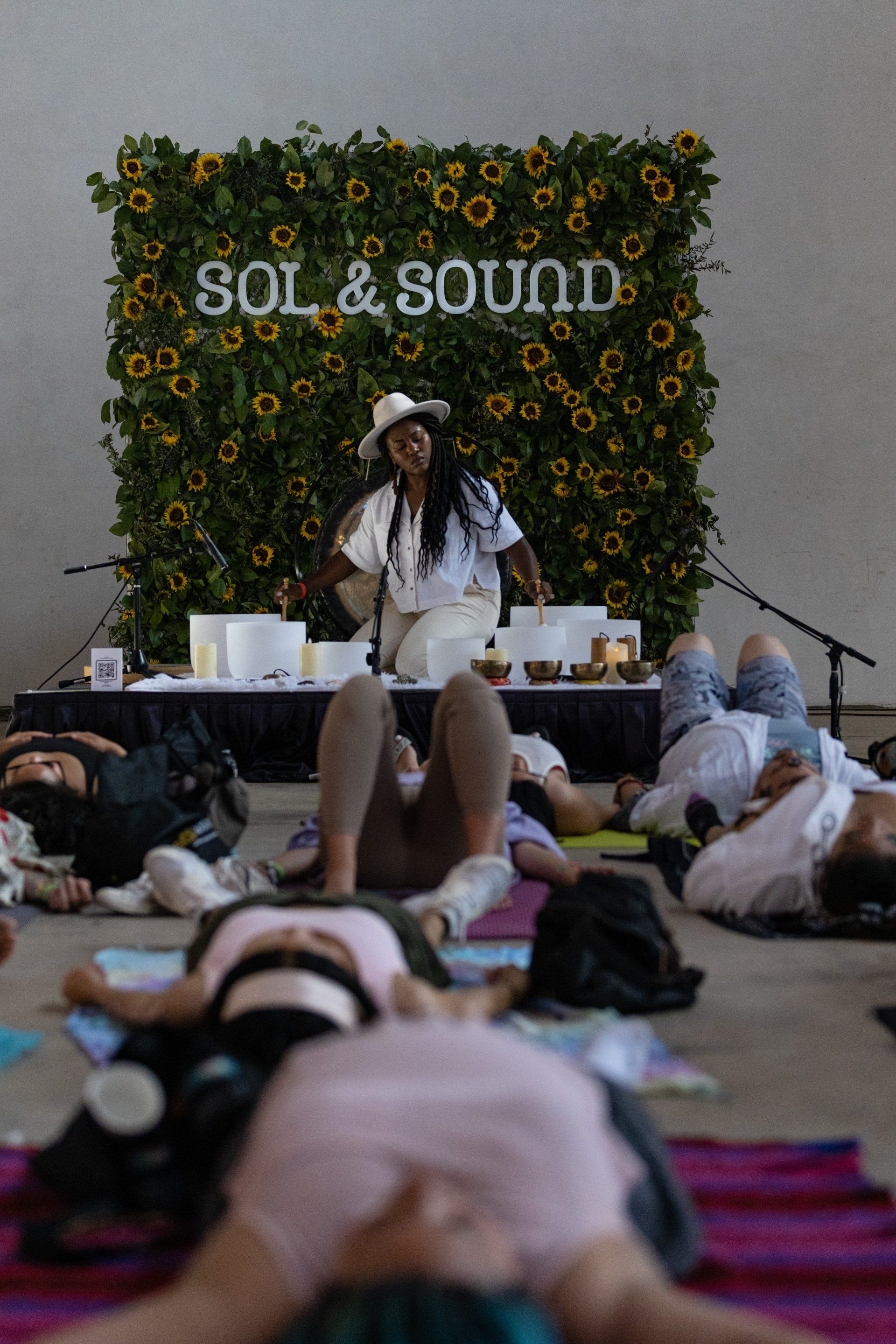 Jennifer Blooms play sound bowls on stage at Sol & sound Festival