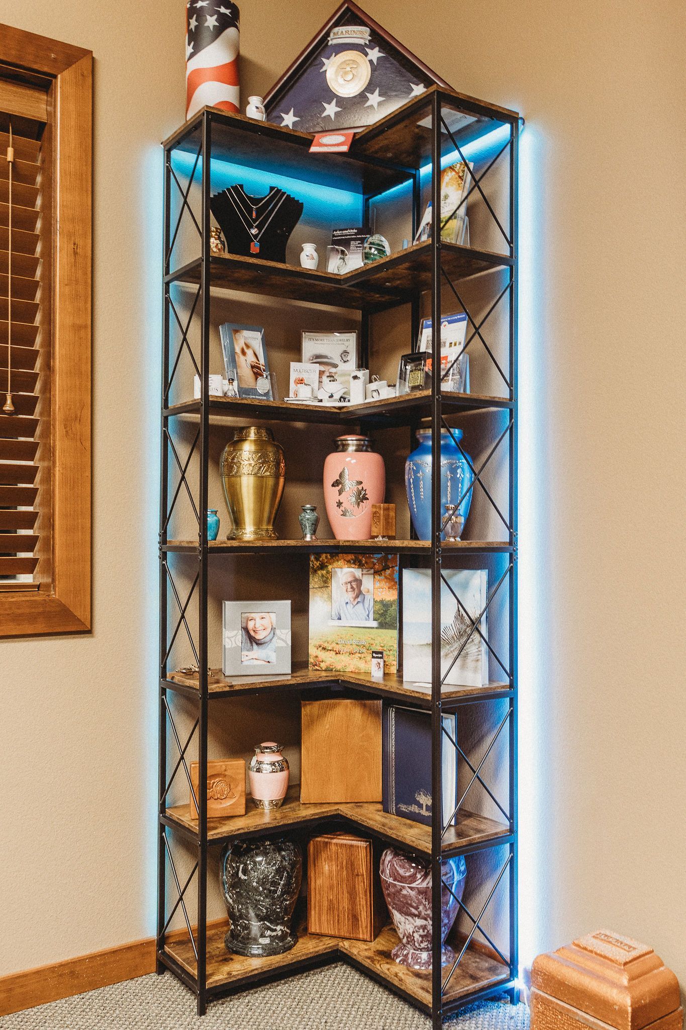 Corner display shelf with bakery-themed items and blue LED lighting in a room
