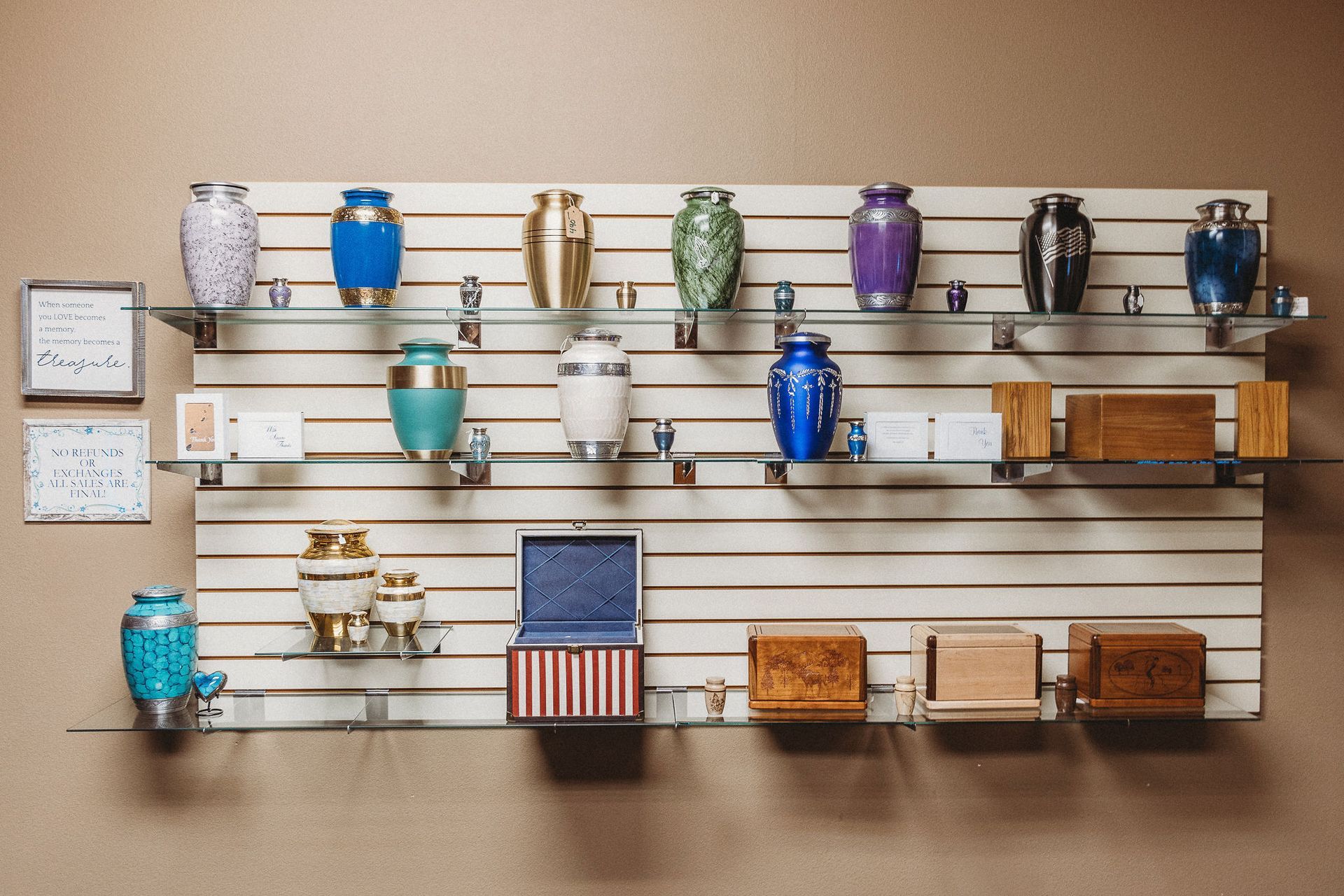 Wall-mounted display of colorful mugs and small decor items on wooden shelves