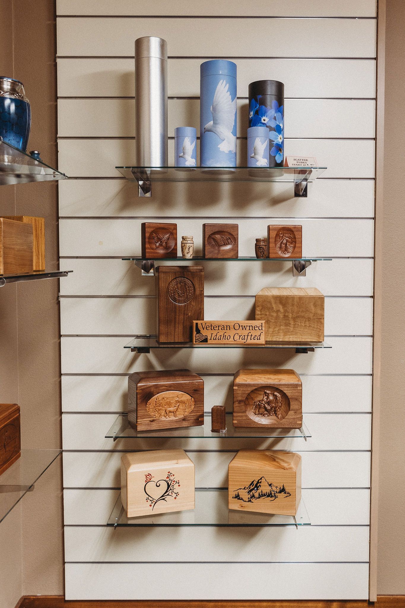 Wall display of assorted packaged goods on shelves against a white slatted background.
