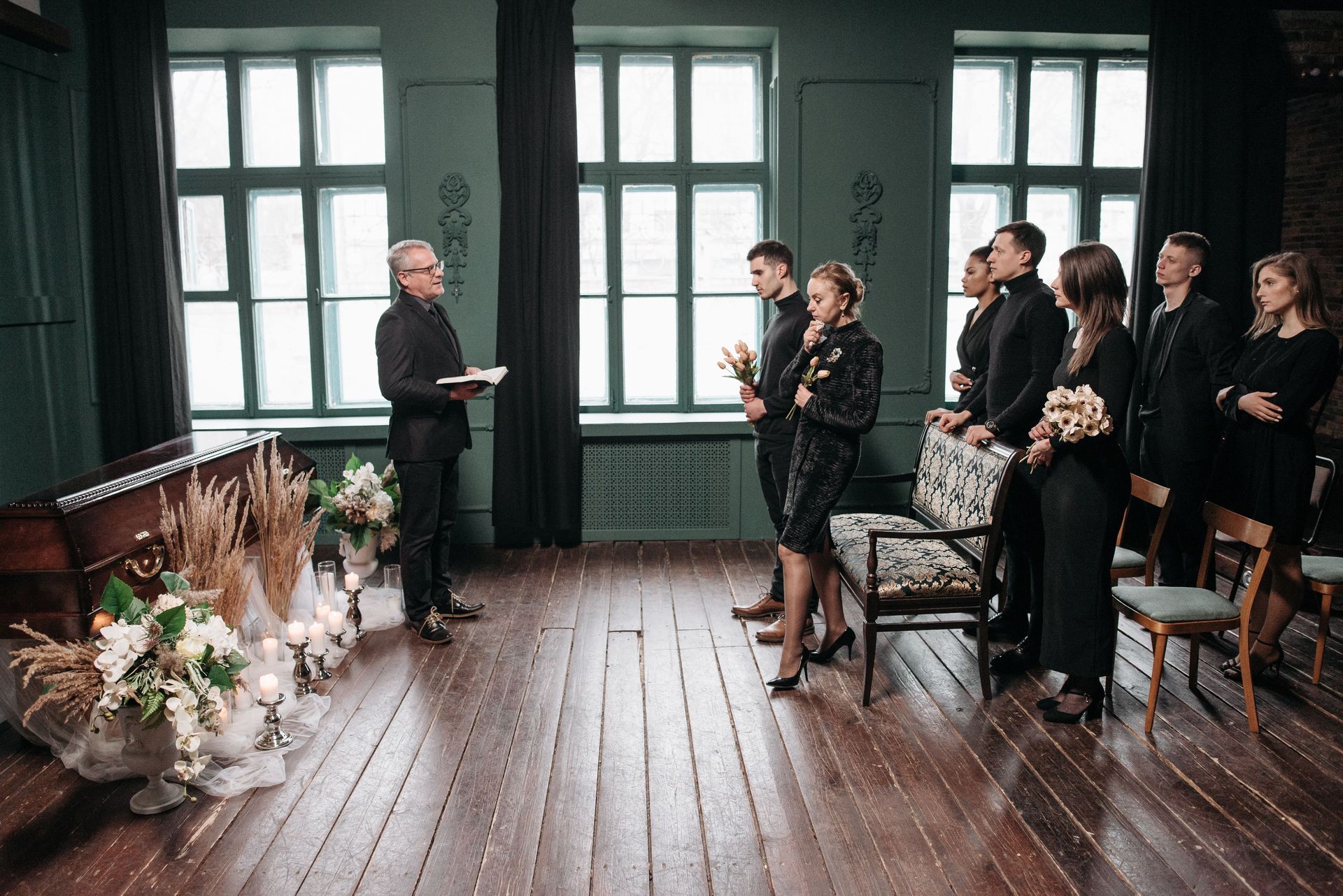 Indoor wedding ceremony with officiant, couple, and guests in a dark wood room