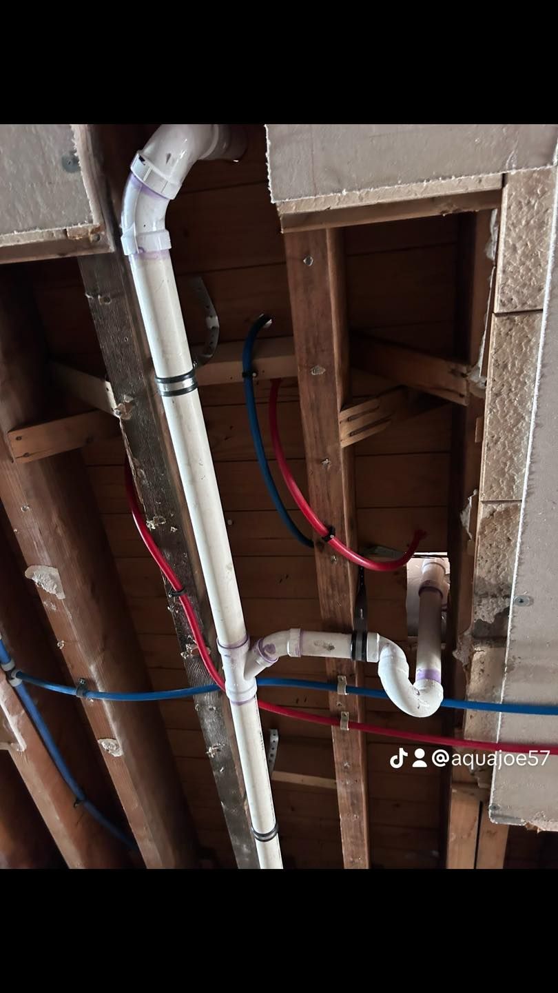 A bunch of pipes are hanging from the ceiling of a building.