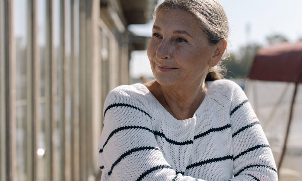 Mature woman standing outside looking confidently to the side