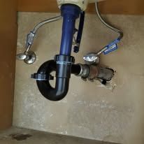 A sink with a blue pipe underneath it.