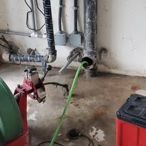 A green pipe is coming out of a hole in the floor.