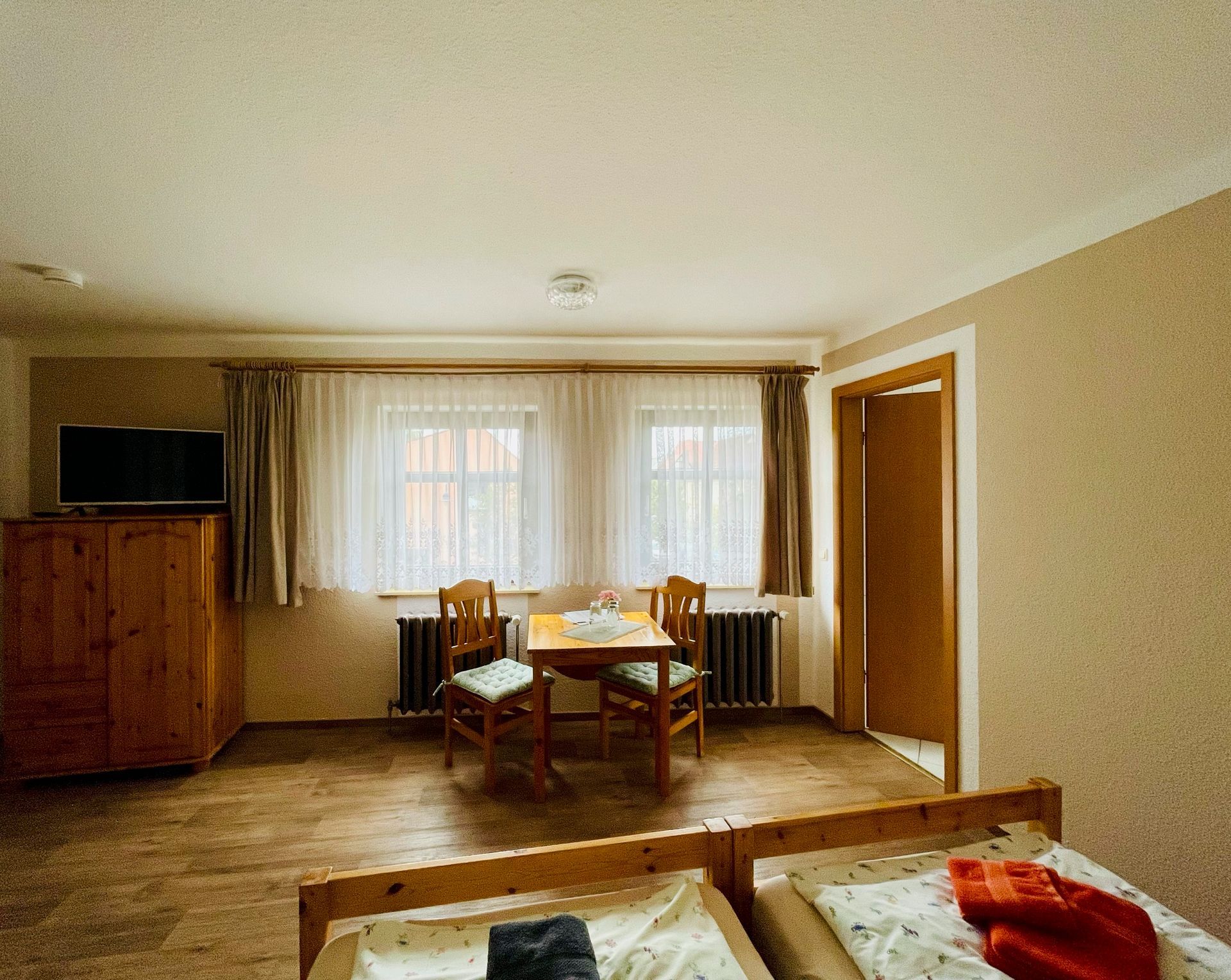 Ein Schlafzimmer mit zwei Betten, einem Tisch und Stühlen.