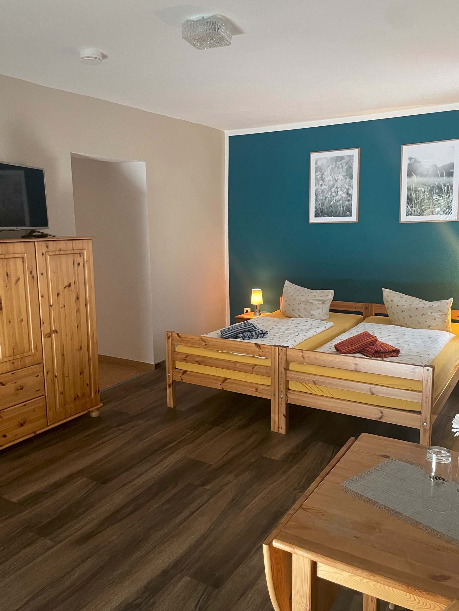 Ein Schlafzimmer mit zwei Betten, einer Kommode und einem Fernseher.