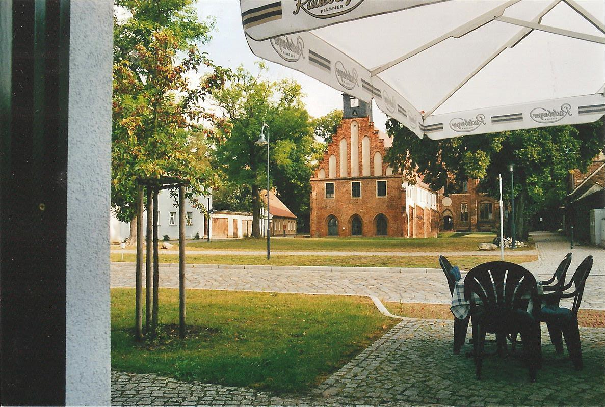 Ein Tisch und Stühle unter einem Sonnenschirm mit einem Gebäude im Hintergrund