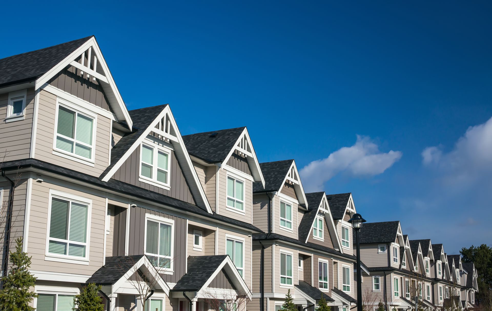 A row of houses with a blue sky in the background.