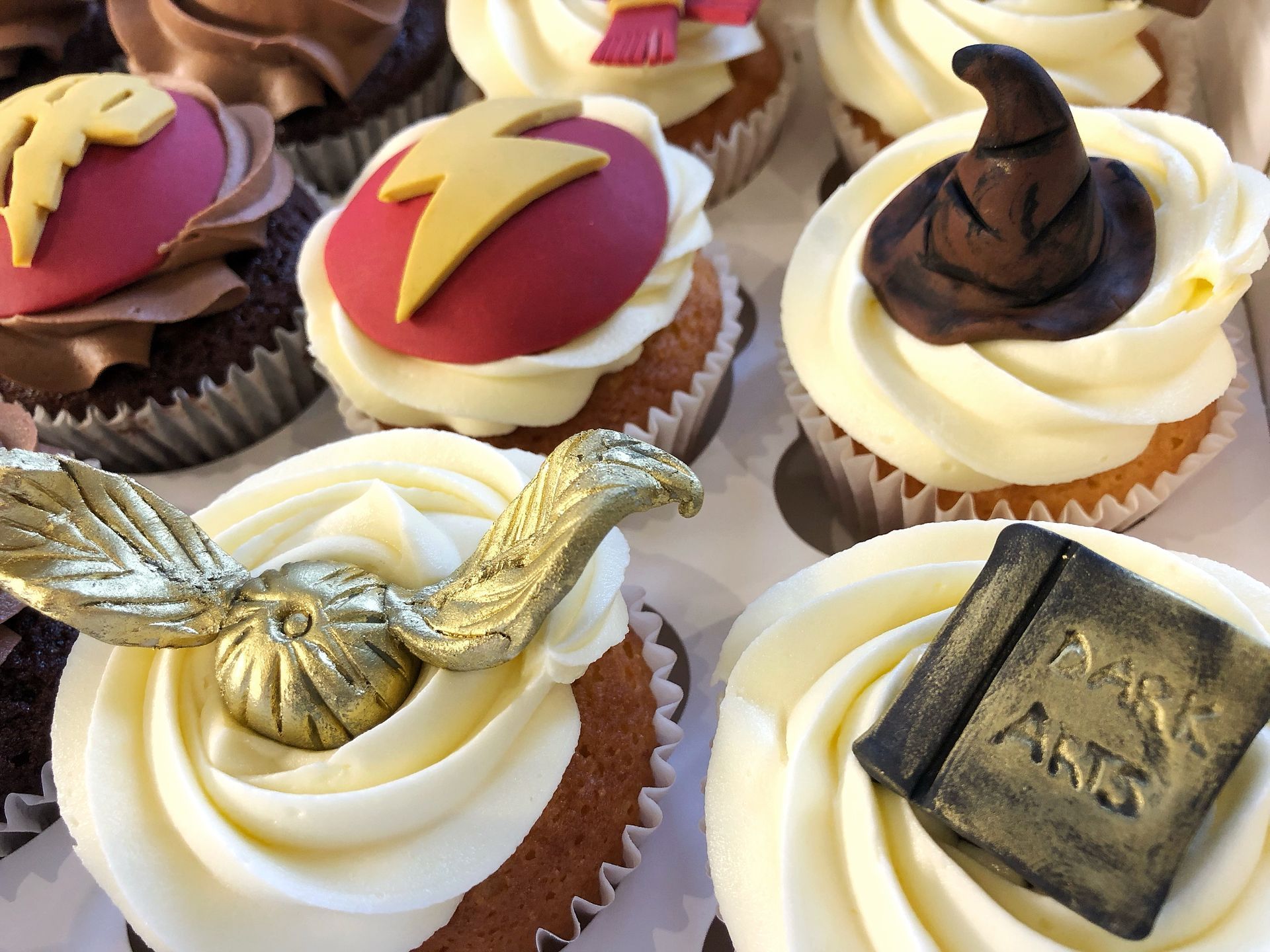 Harry Potter themed cupcakes with fondant witches hats, lightening bolts gold Snitches, book of spells.