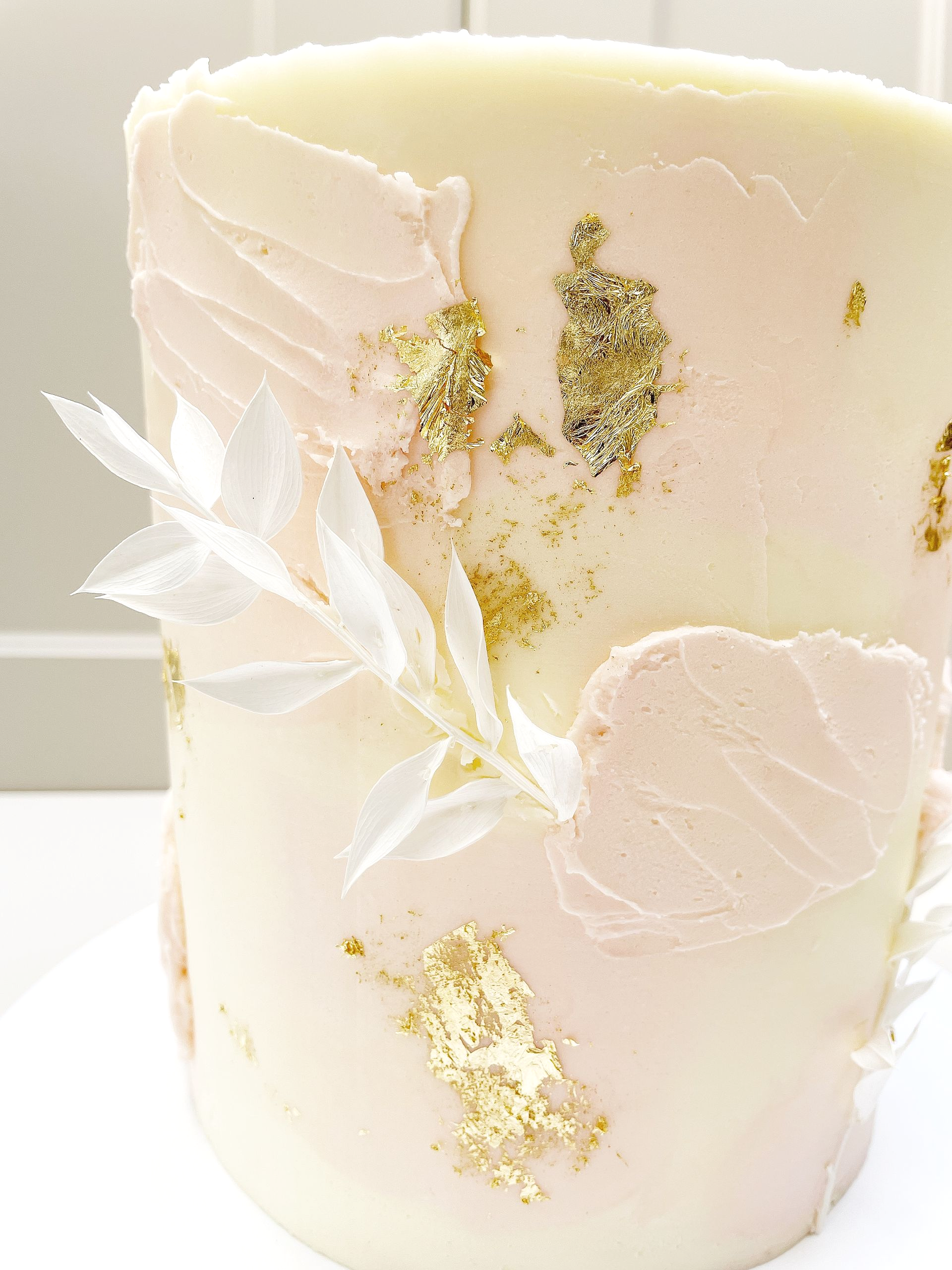 Ivory Buttercream covered cake with Tiffany blue buttercream stencil and piping work and a name in gold on the side of the cake.