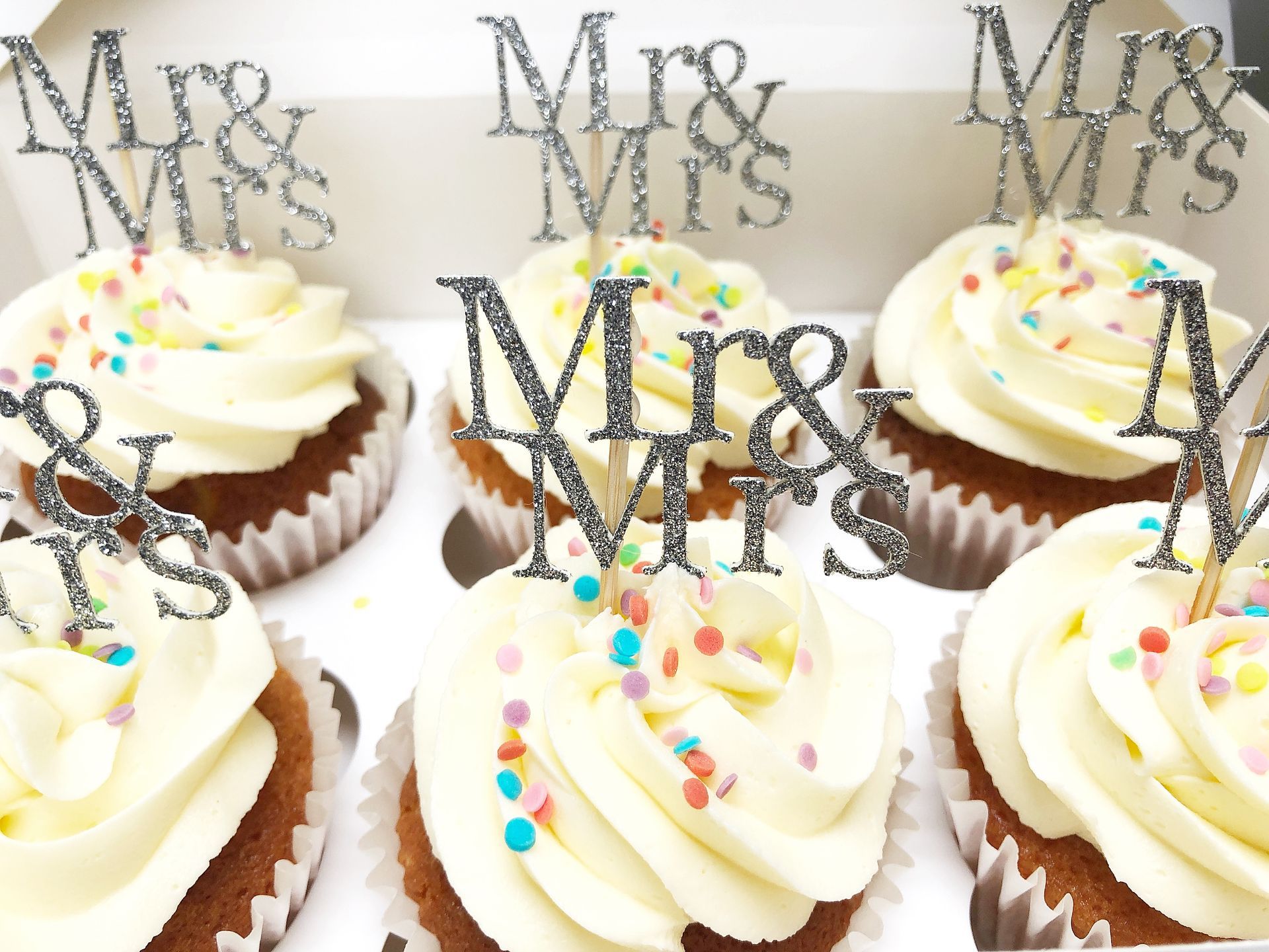 Vanilla Cupcakes with confetti sprinkles and Mr & Mrs cake toppers in silver.