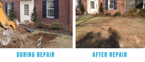 Person in orange work pants and boots, vacuuming a sewer manhole on a paved street.
