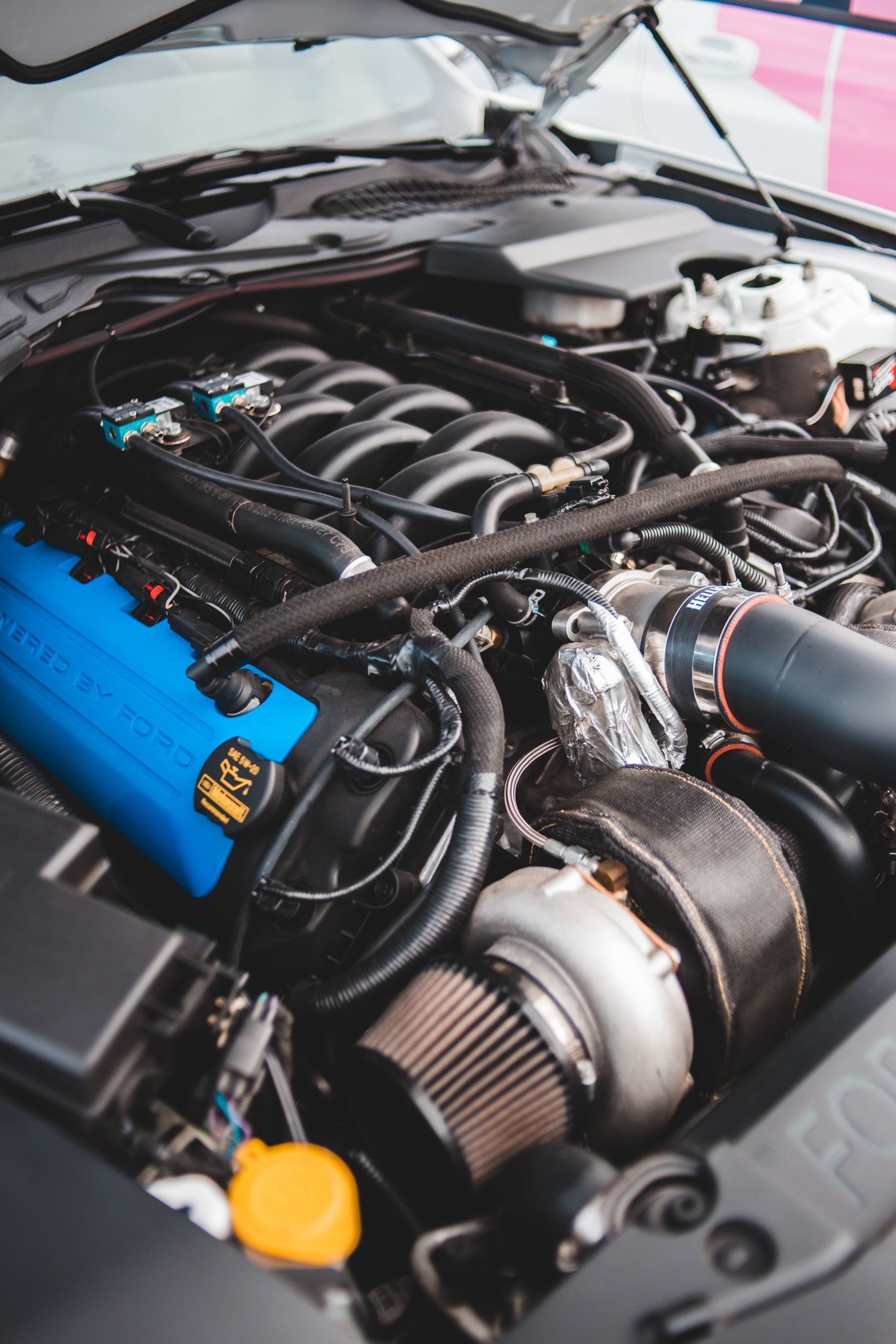 A close up of a car engine with the hood open.