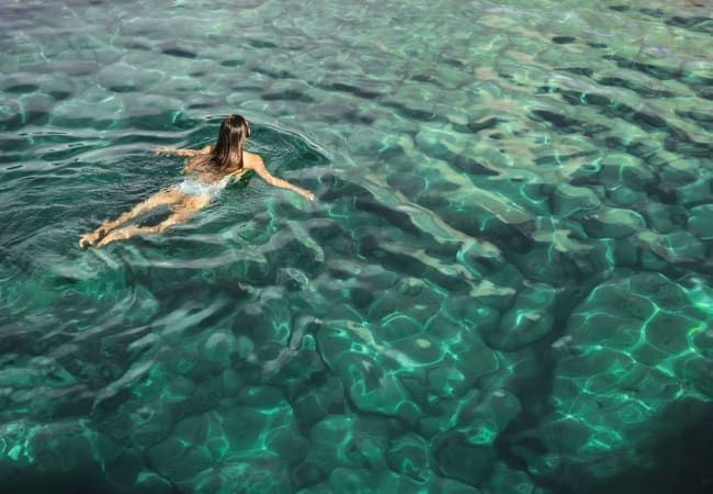 A woman is sitting on a yoga mat at Livano Wildwood