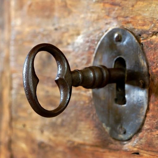A key in a keyhole on a wooden door