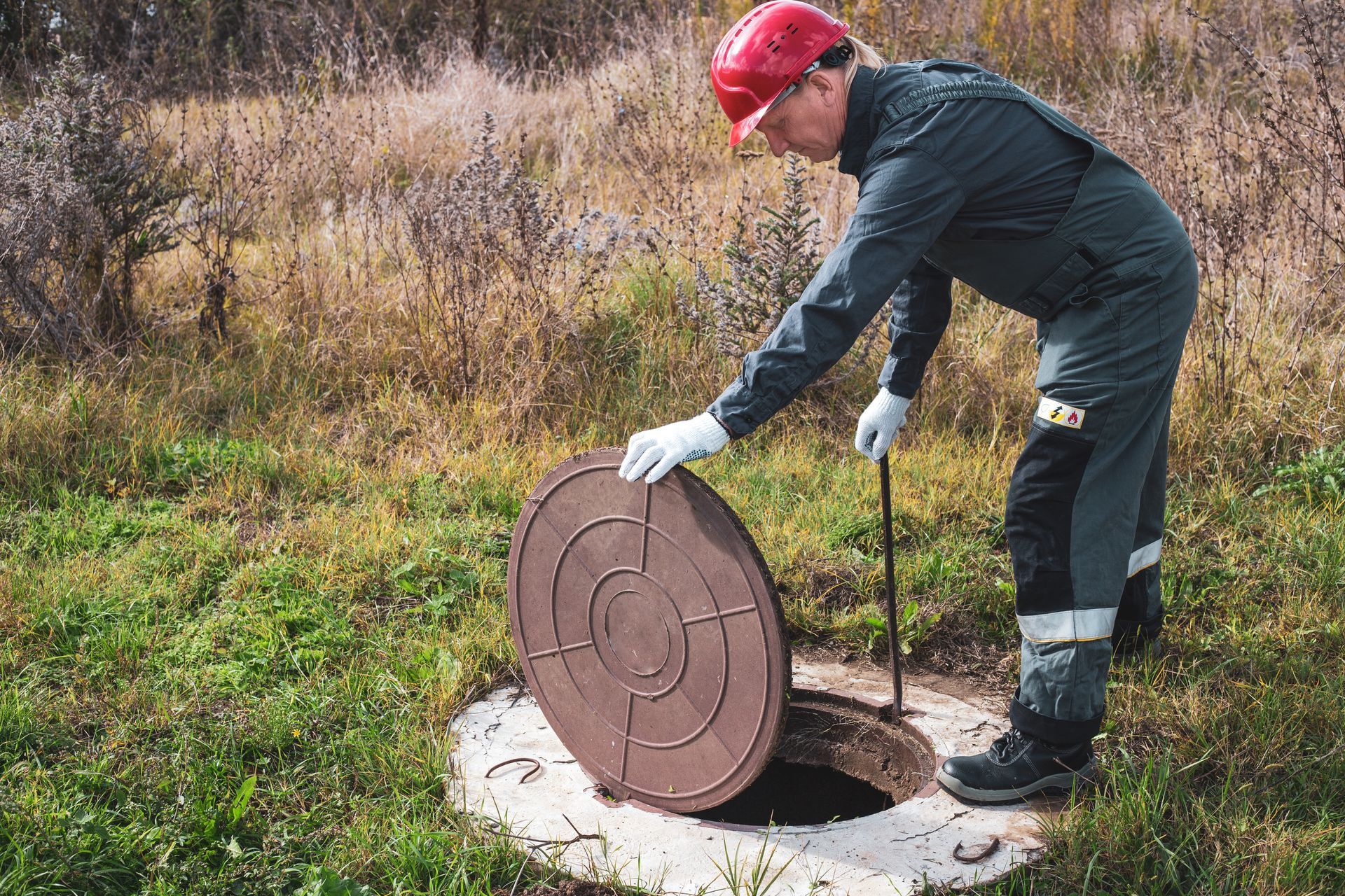 A man is opening a septic tank.