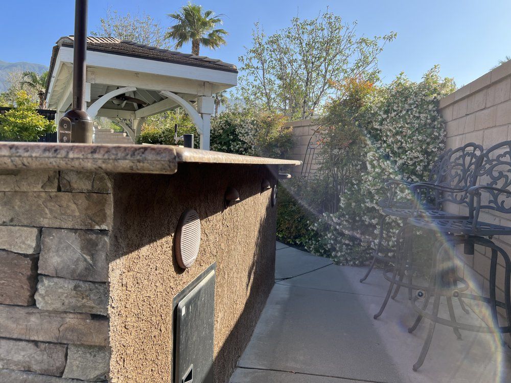 Stone bar with a gazebo and palm tree in the background. Sunny day.