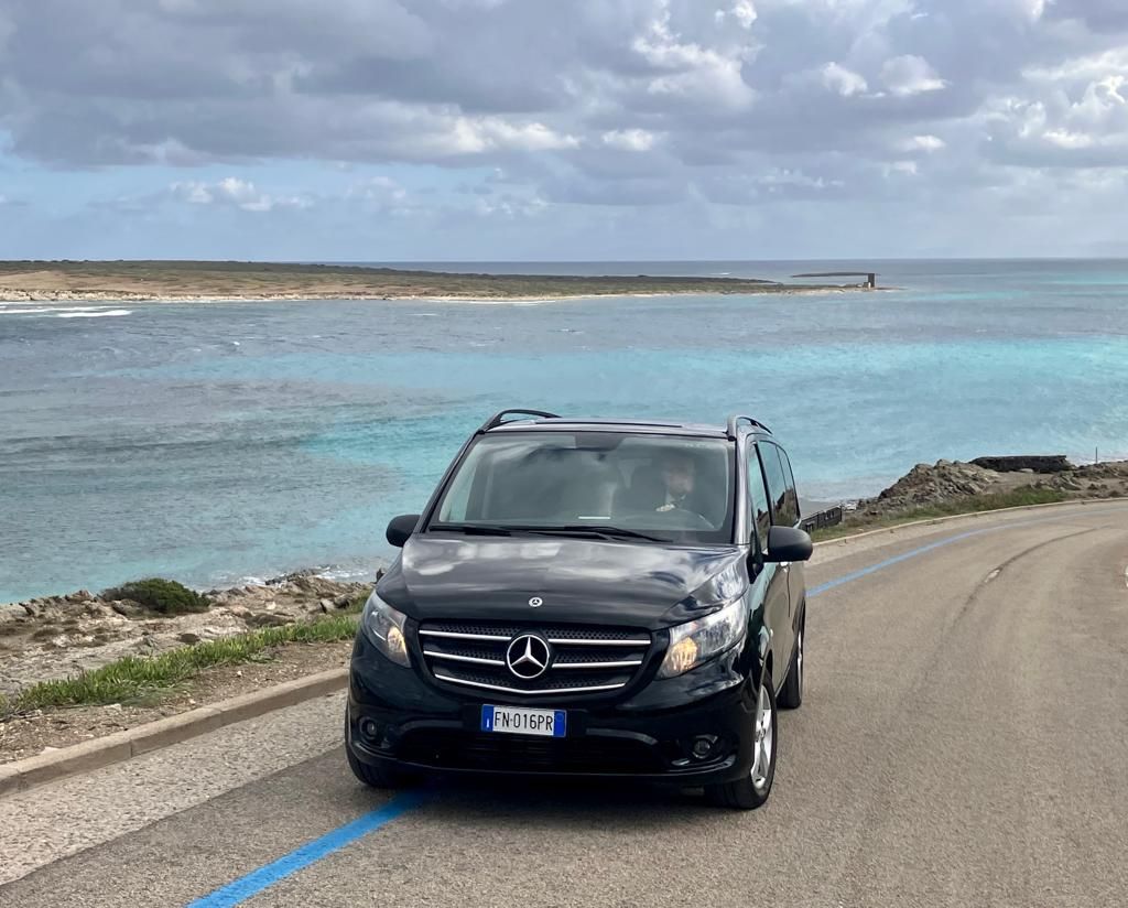 una mercedes benz è parcheggiata su una strada vicino al mare