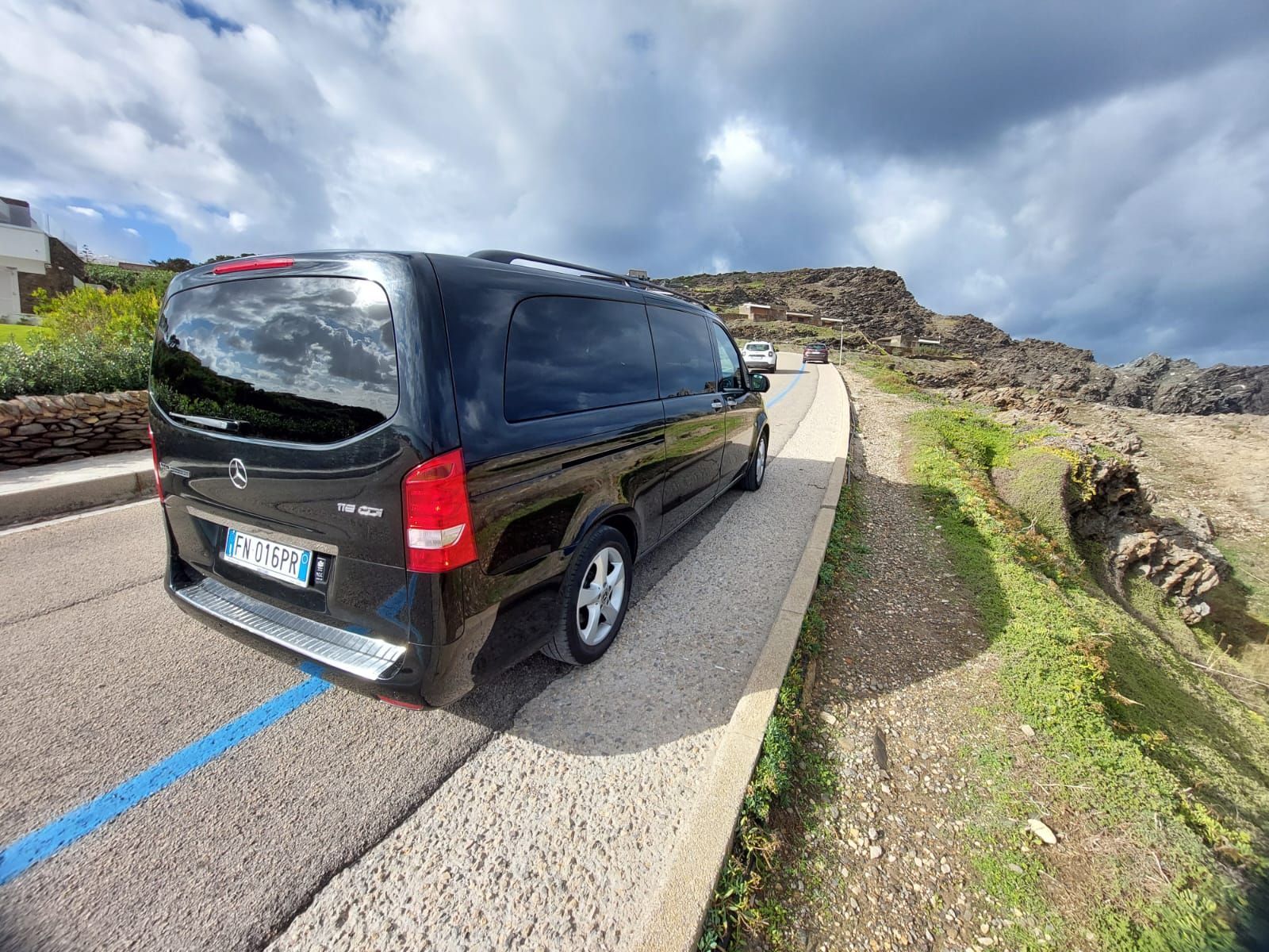 un furgone nero è parcheggiato su una strada sterrata