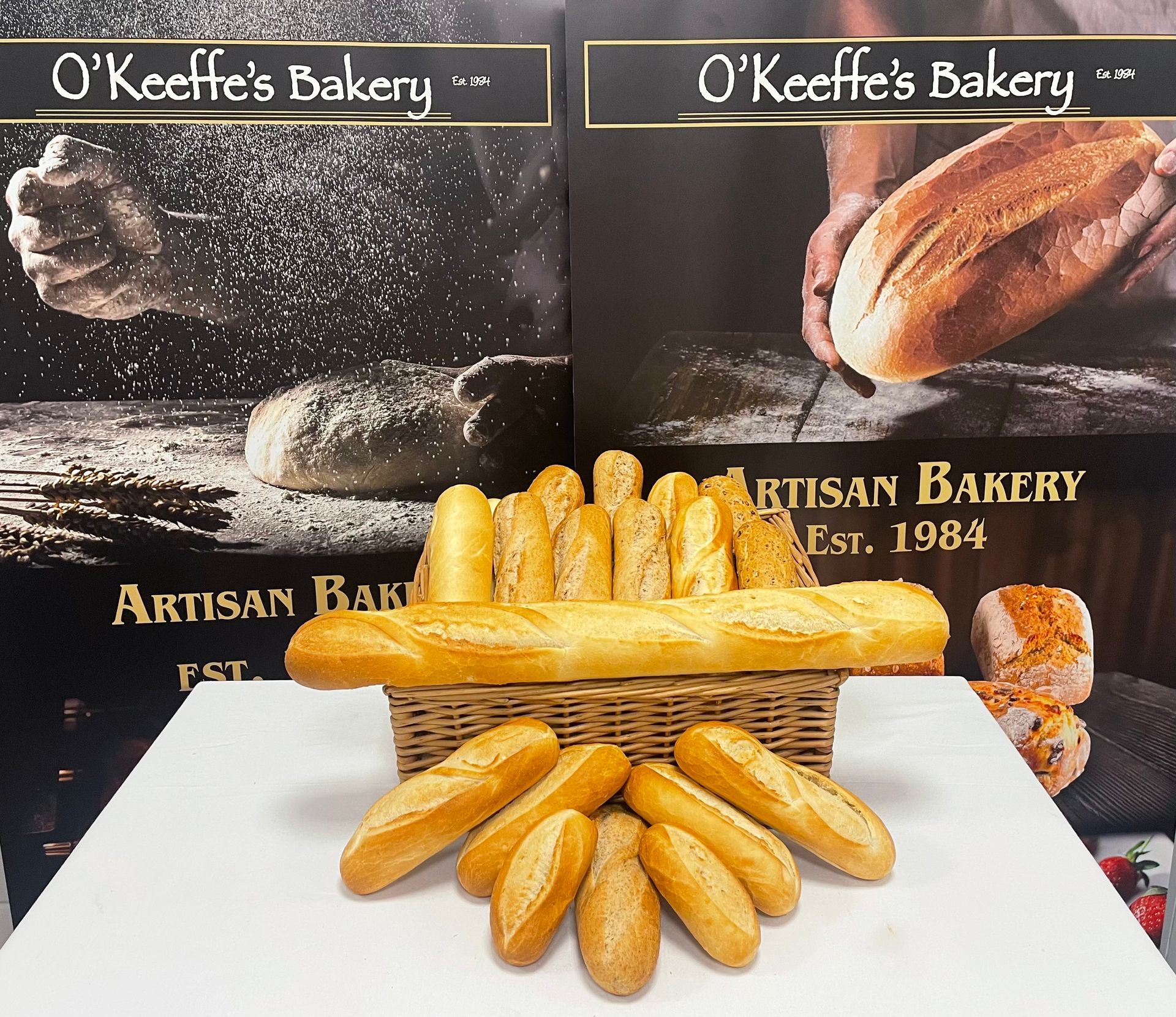 A bunch of loaves of bread in a basket from o'keeffe 's bakery