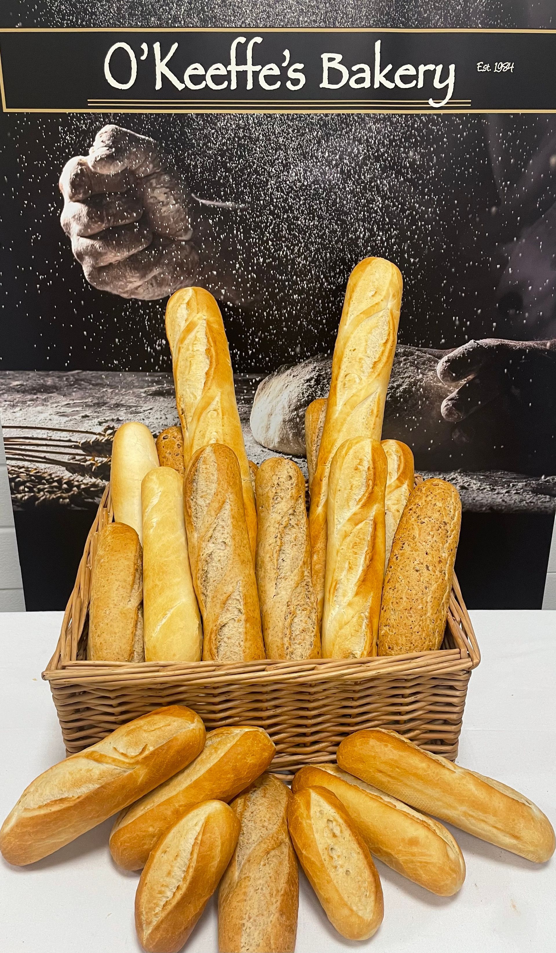 A basket of bread is on a table in front of a sign that says o ' keeffe 's bakery