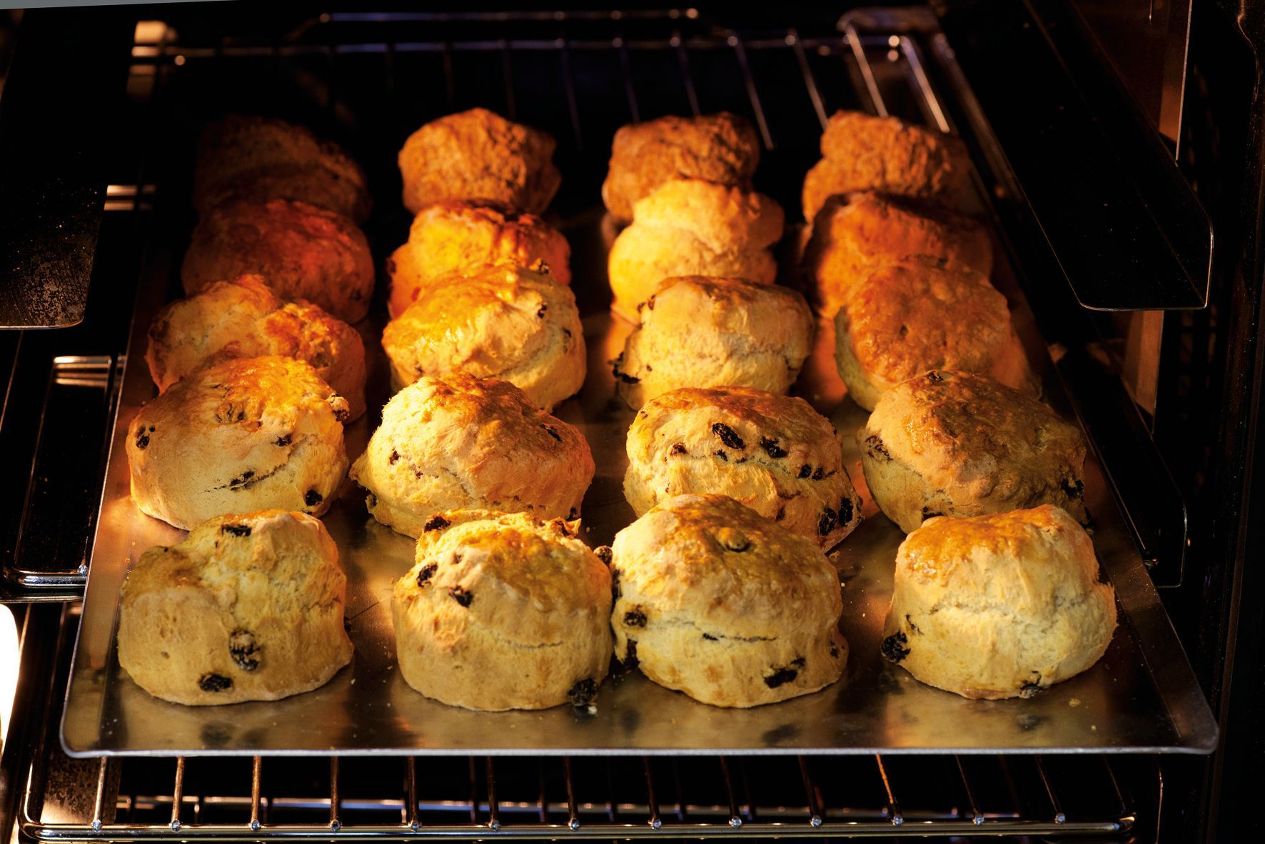 A bunch of scones are baking in an oven