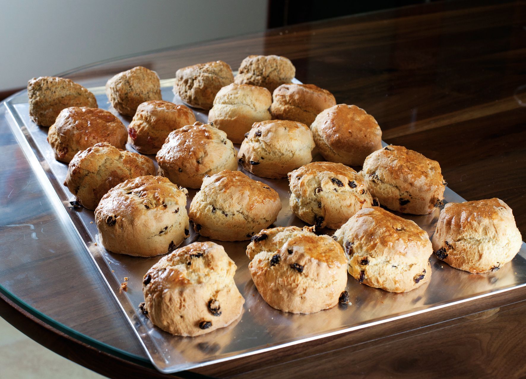 A tray of scones and muffins on a table