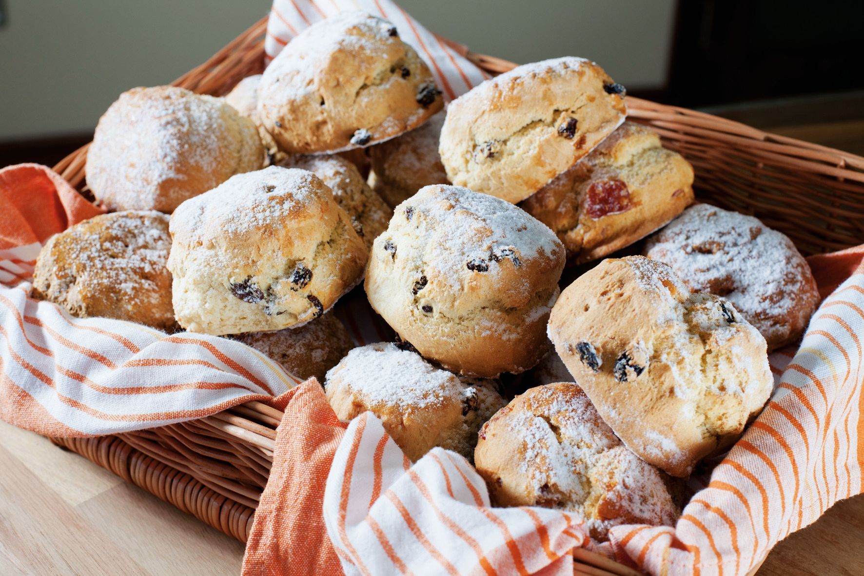 A basket filled with muffins covered in powdered sugar