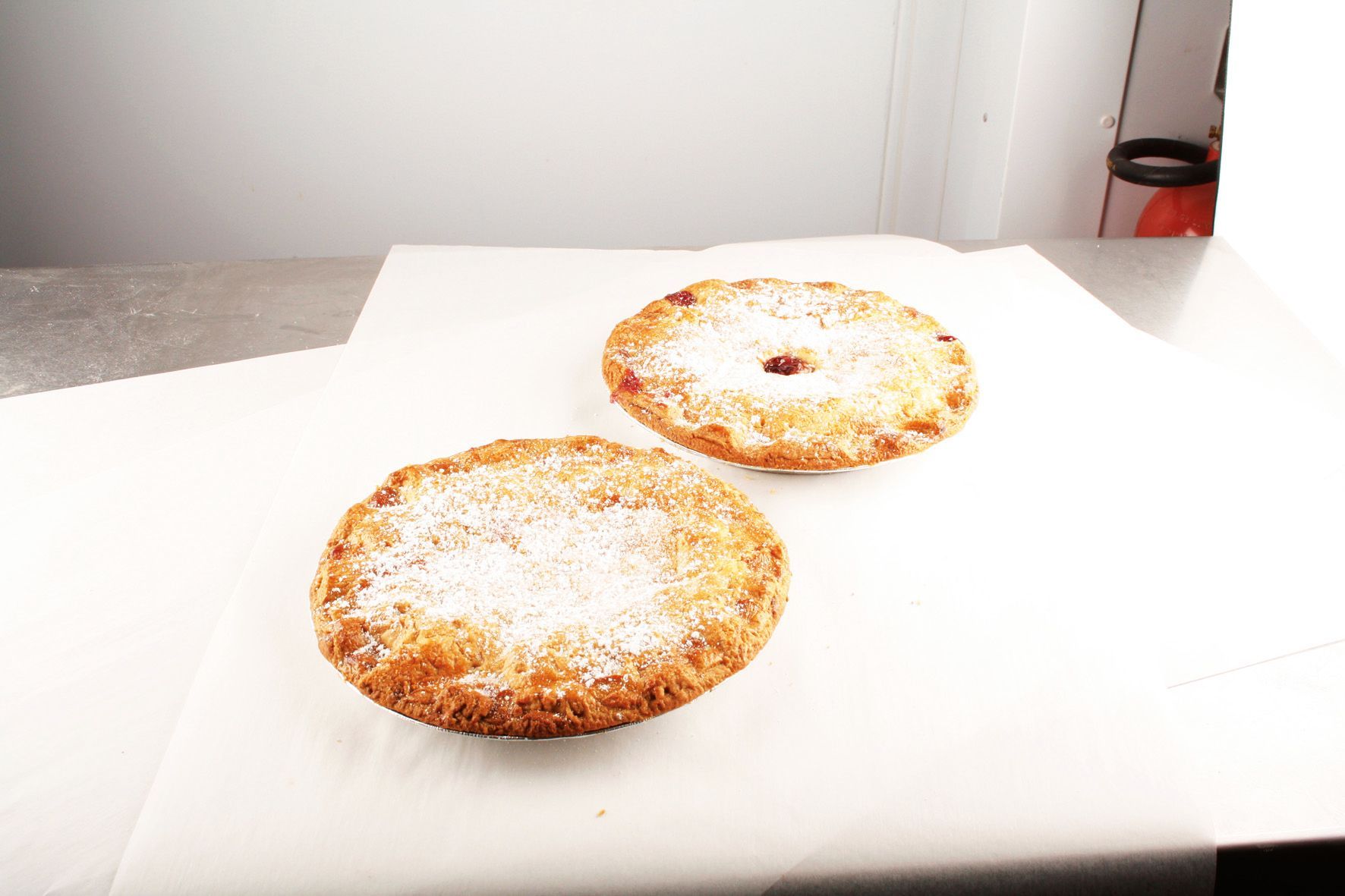 Two pies with powdered sugar on them are on a table