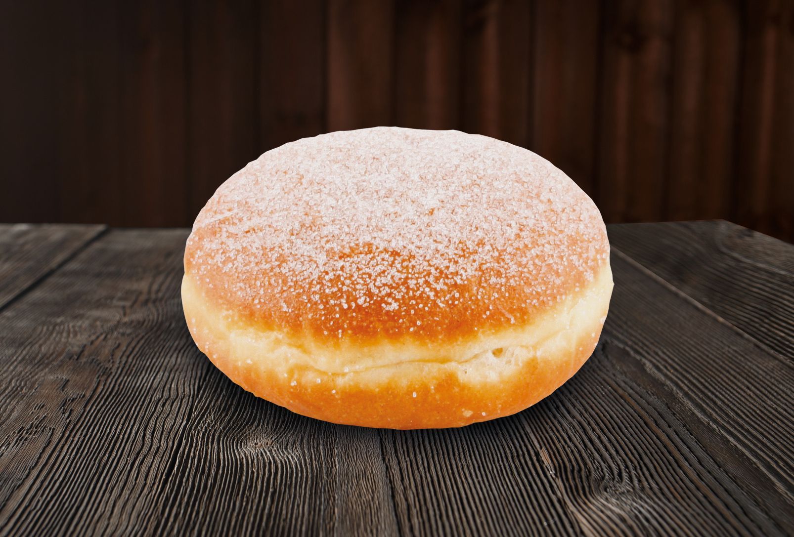 A donut with powdered sugar on top is sitting on a wooden table.