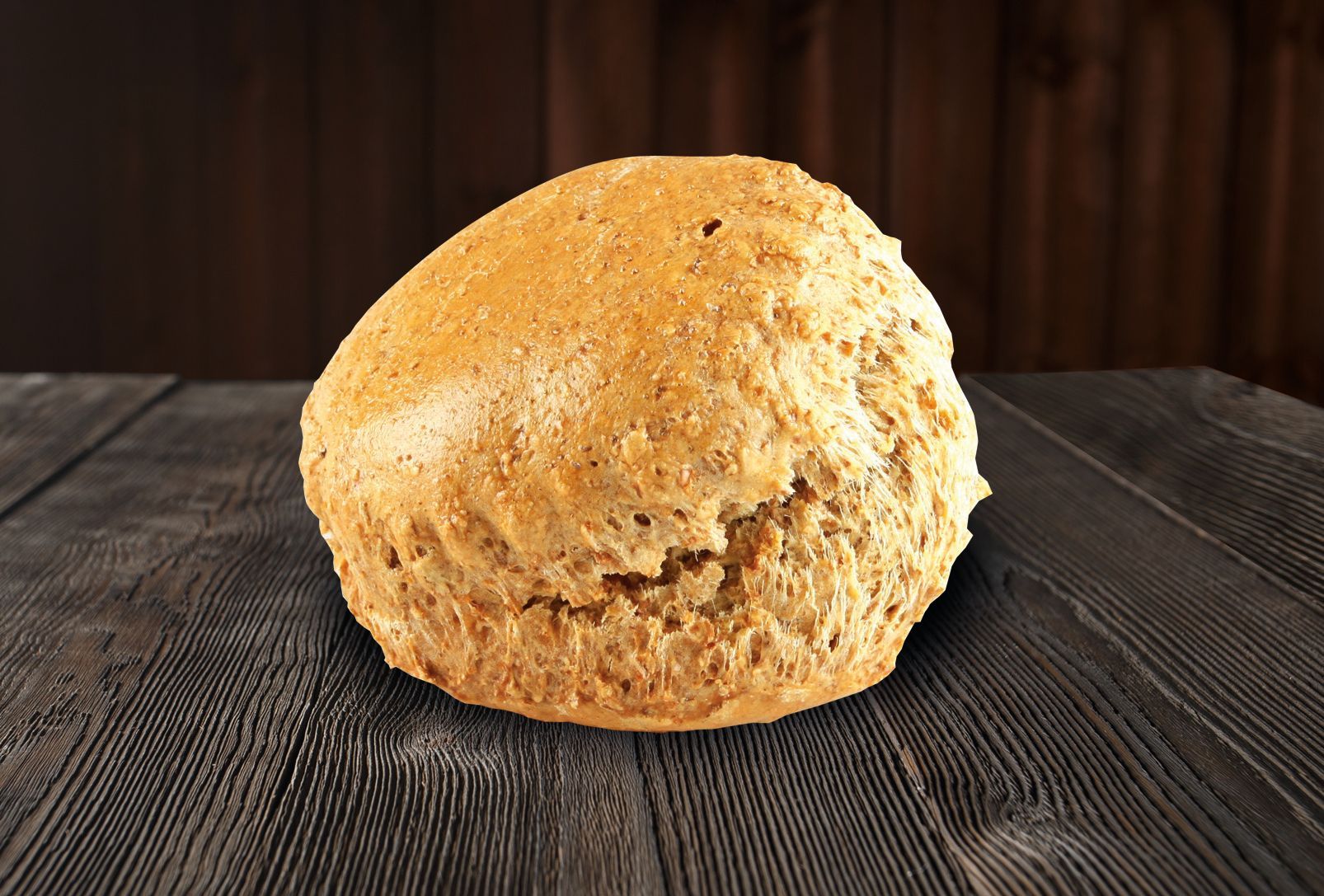 A loaf of bread is sitting on a wooden table.