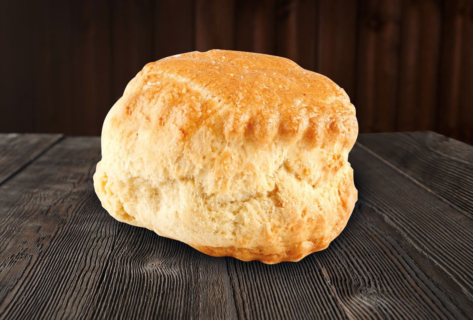 A biscuit is sitting on a wooden table.