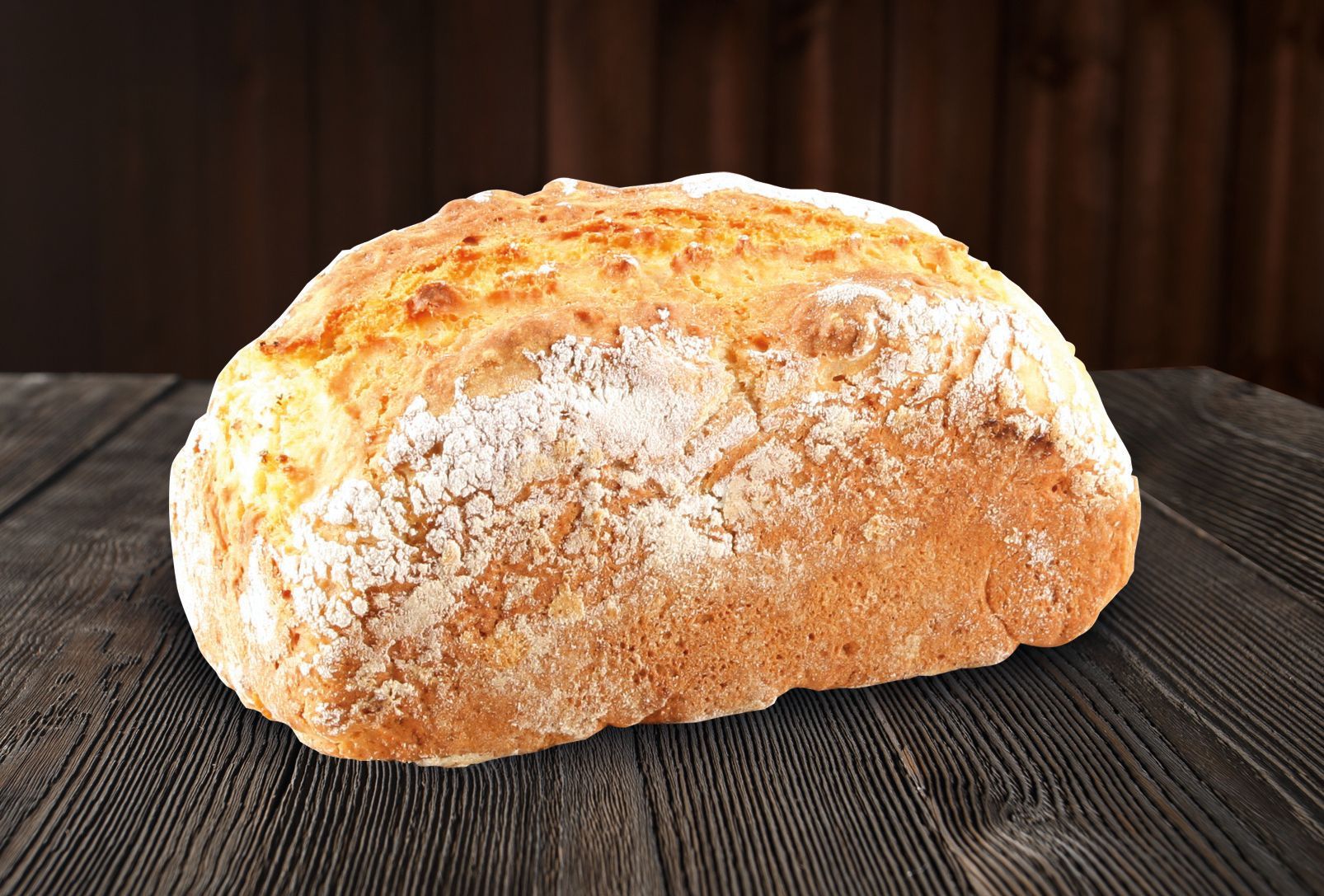 A loaf of bread is sitting on a wooden table.