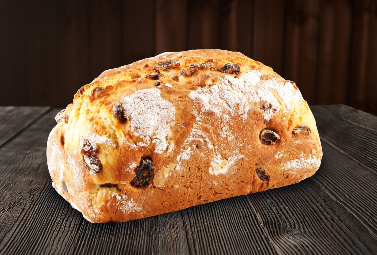 A loaf of bread is sitting on a wooden table.