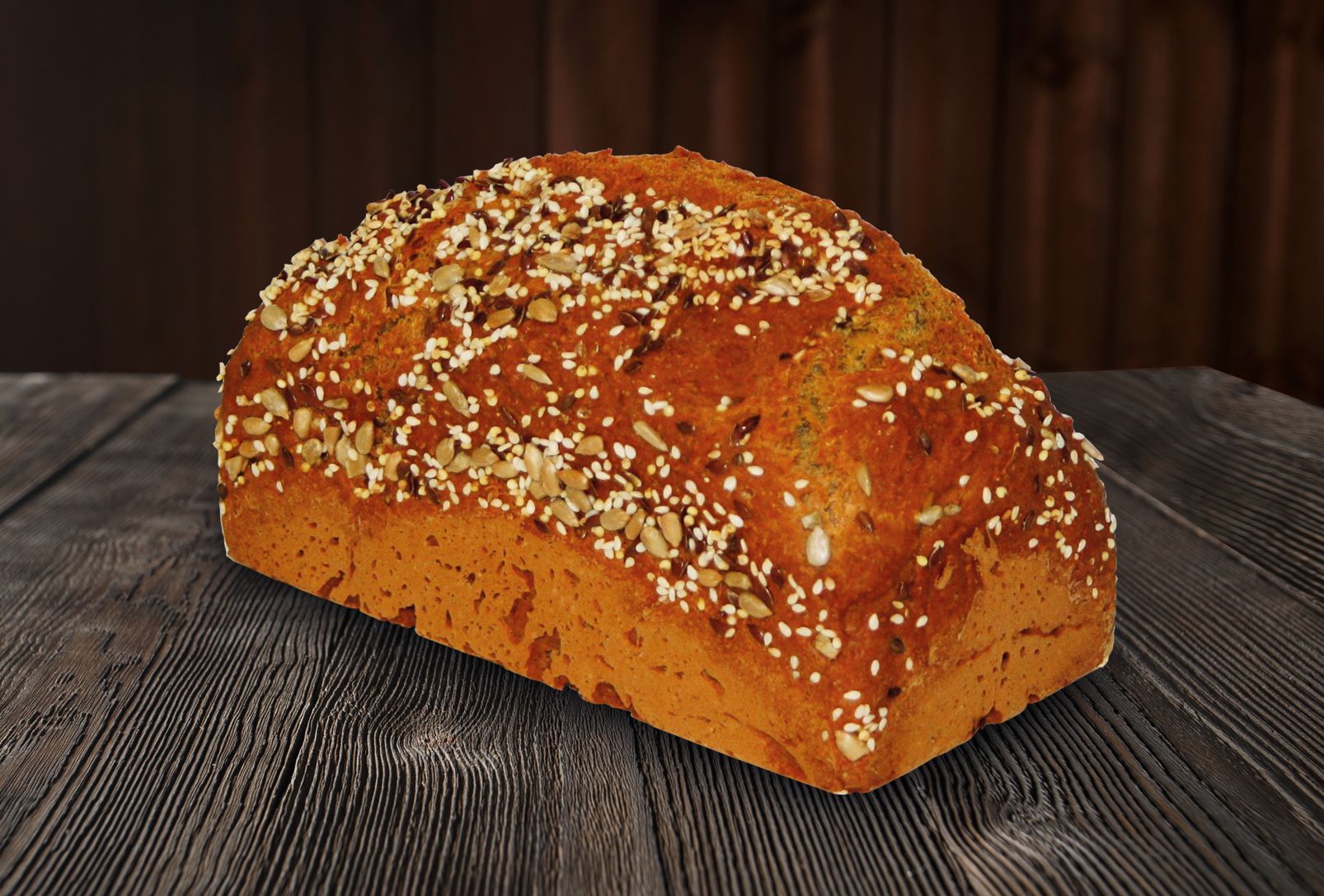 A loaf of bread with sesame seeds on it is sitting on a wooden table.
