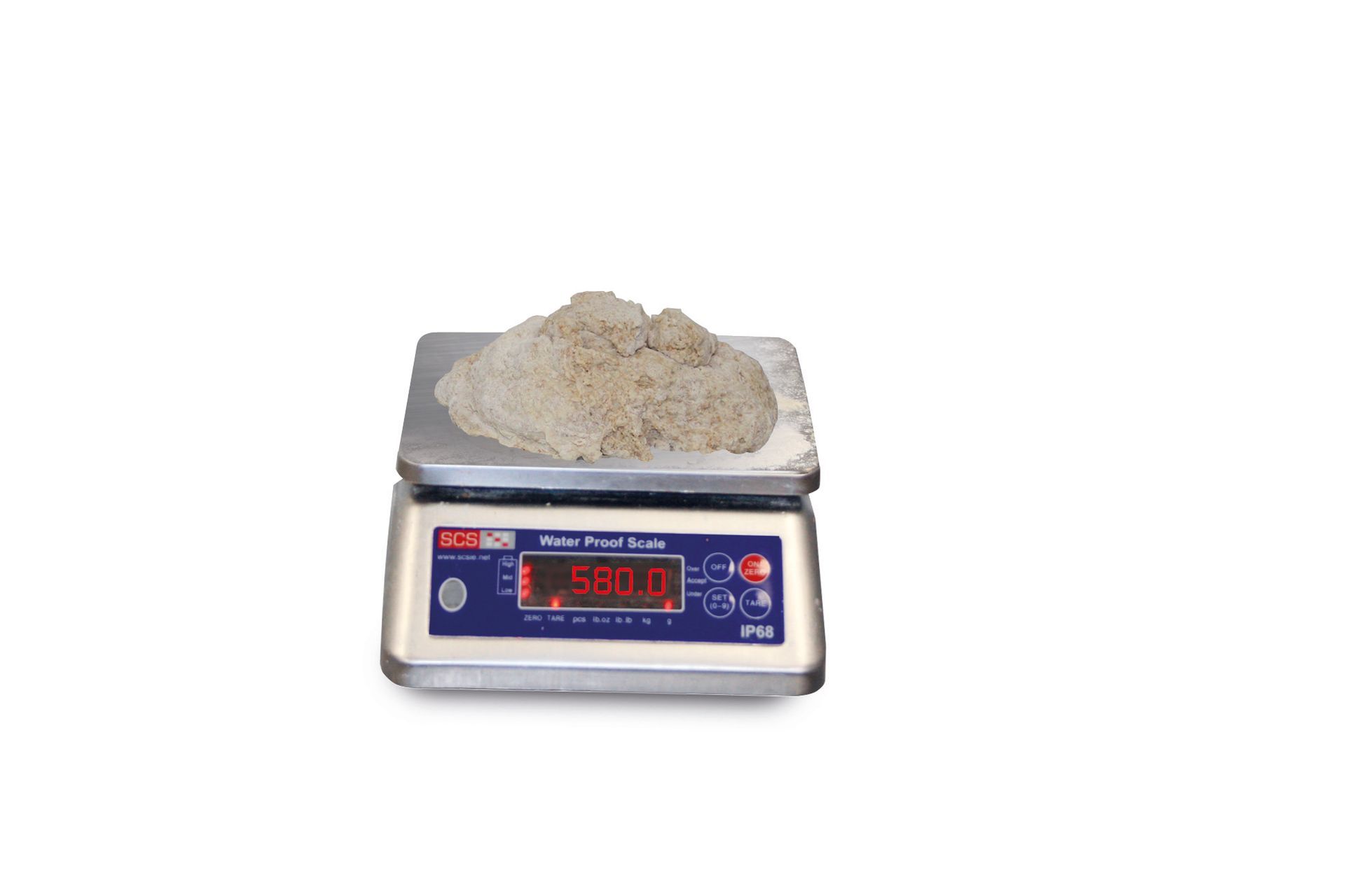 A digital scale with a pile of sand on top of it.