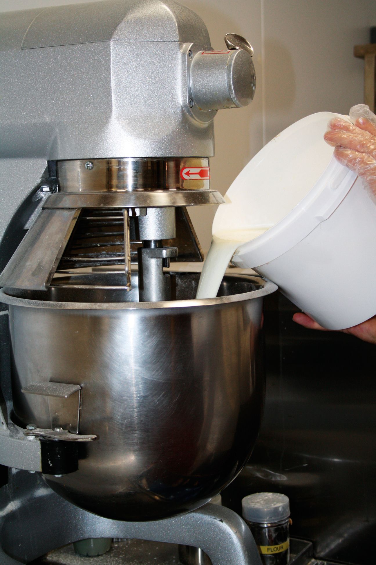 A person is pouring milk into a mixer